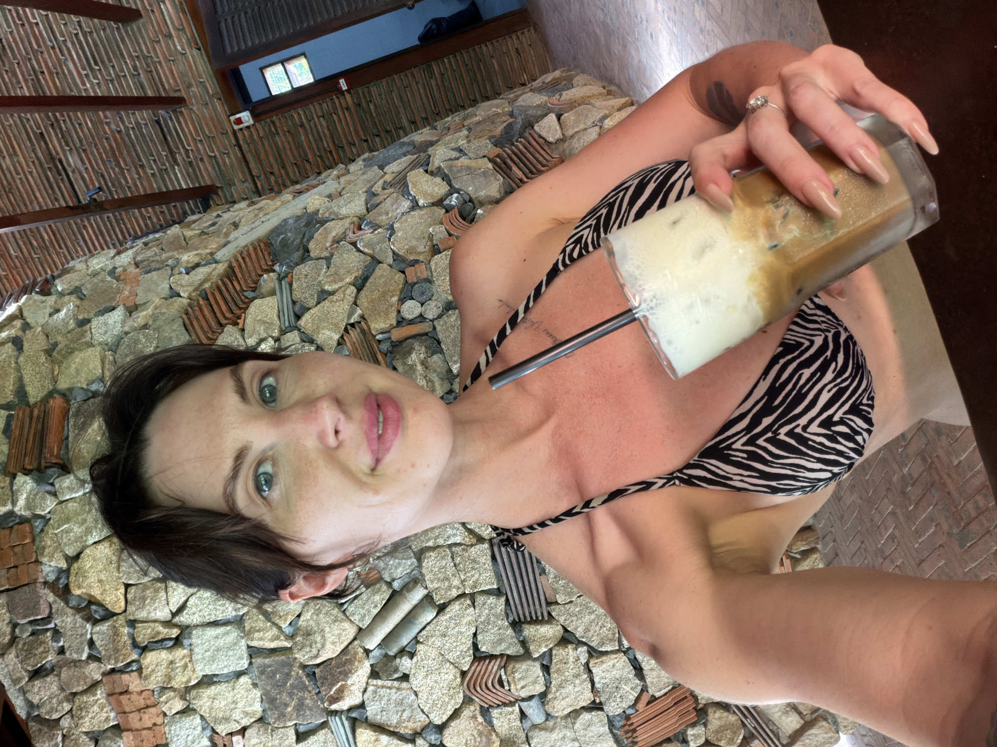 Woman enjoys morning coffee at Vietnamese resort cafe