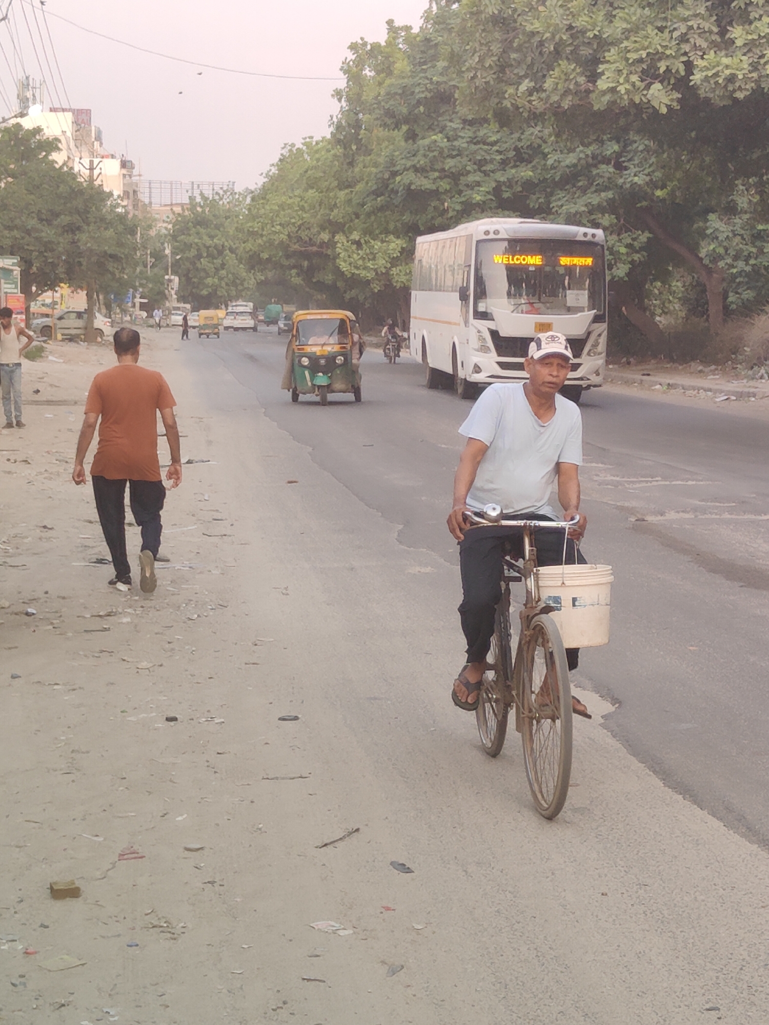 Everyday street life and rooftop birds along a Gurgaon road