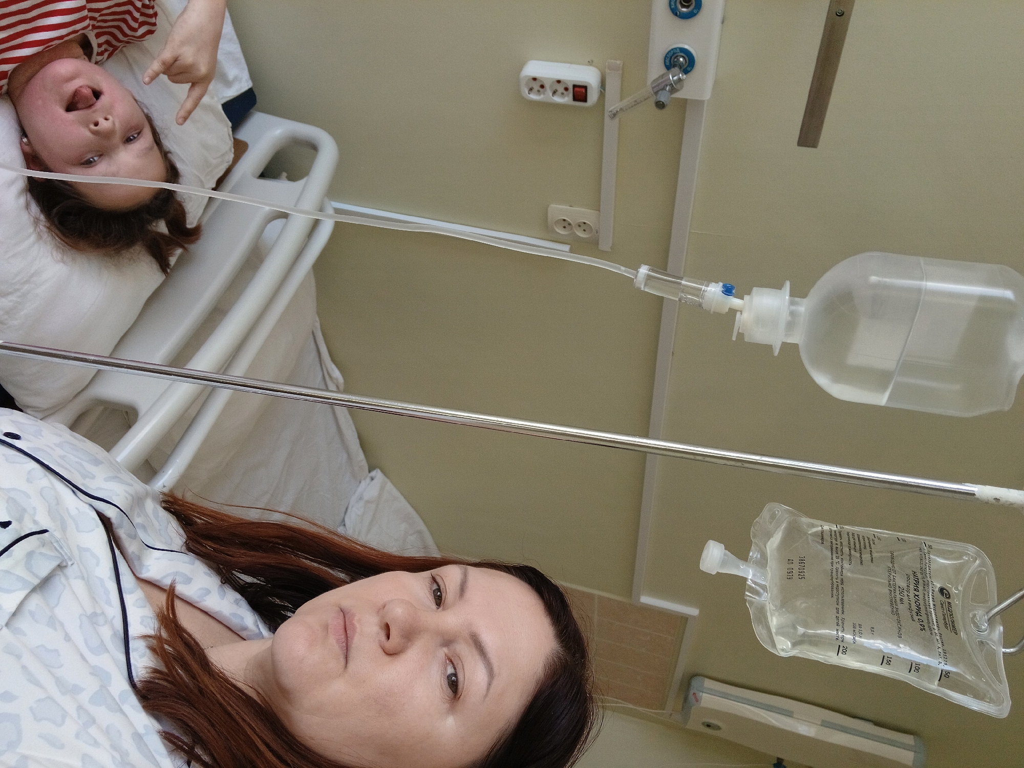Woman receives IV treatment in hospital bed