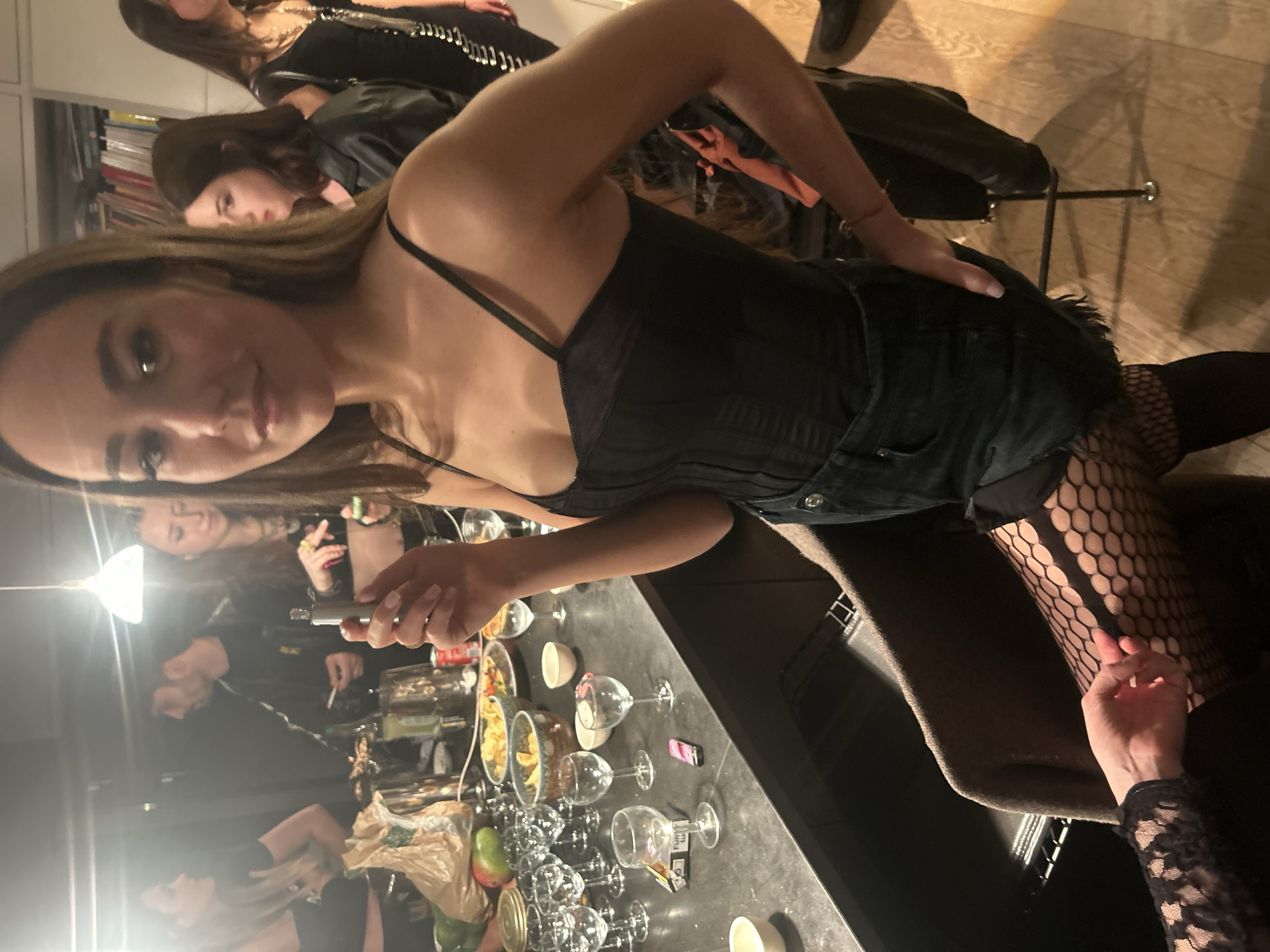Indoor social gathering with multiple attendees in black attire