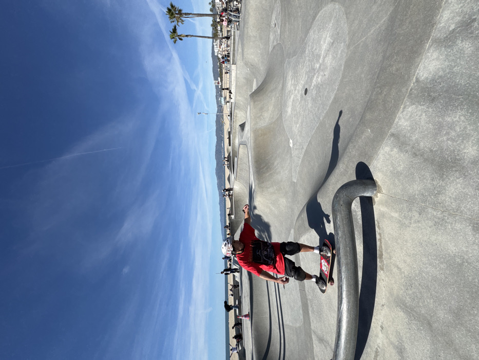 Skateboarder performs rail trick at beachside Los Angeles skatepark