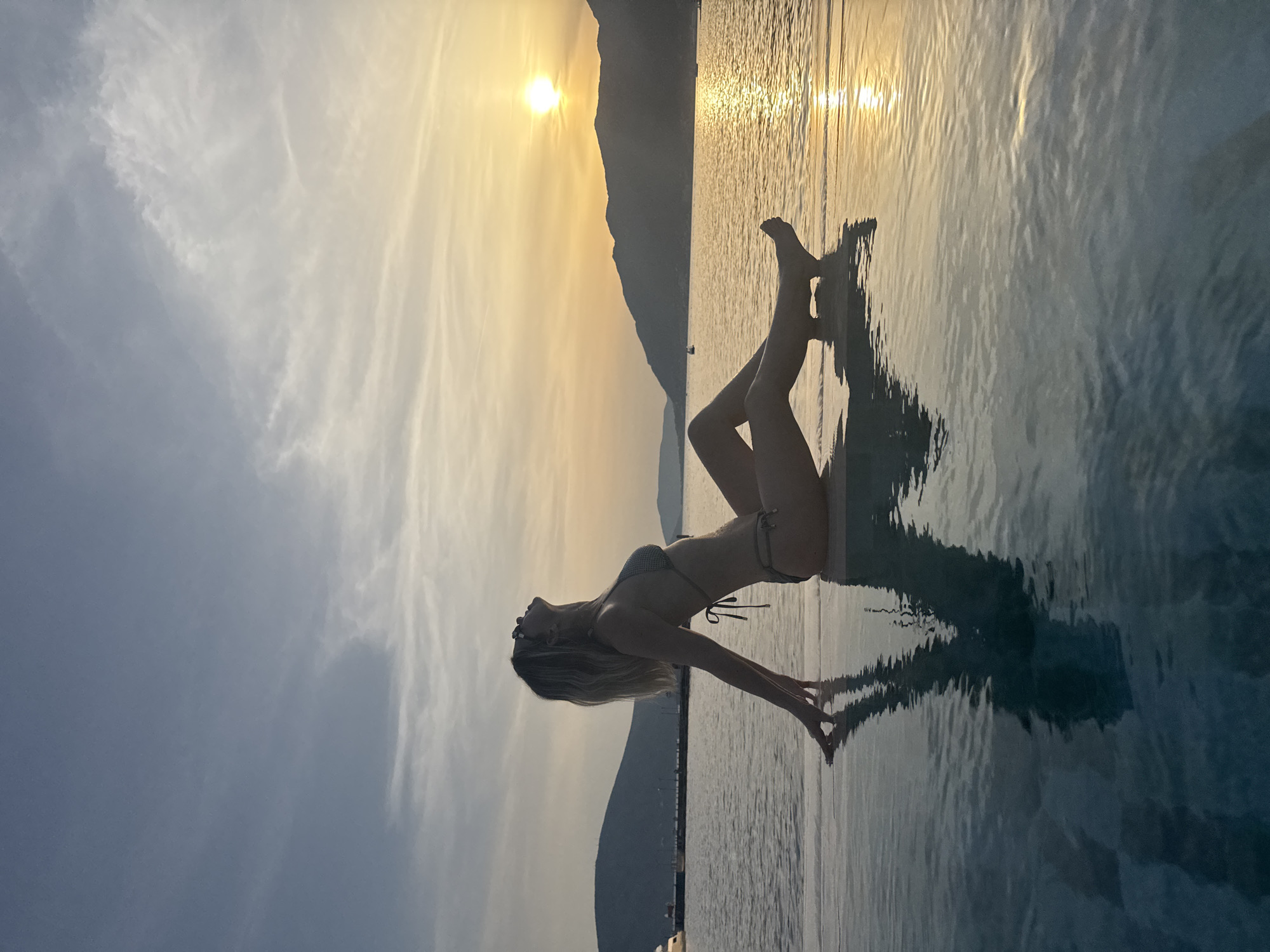 Infinity pool sunset, arms outstretched over the water