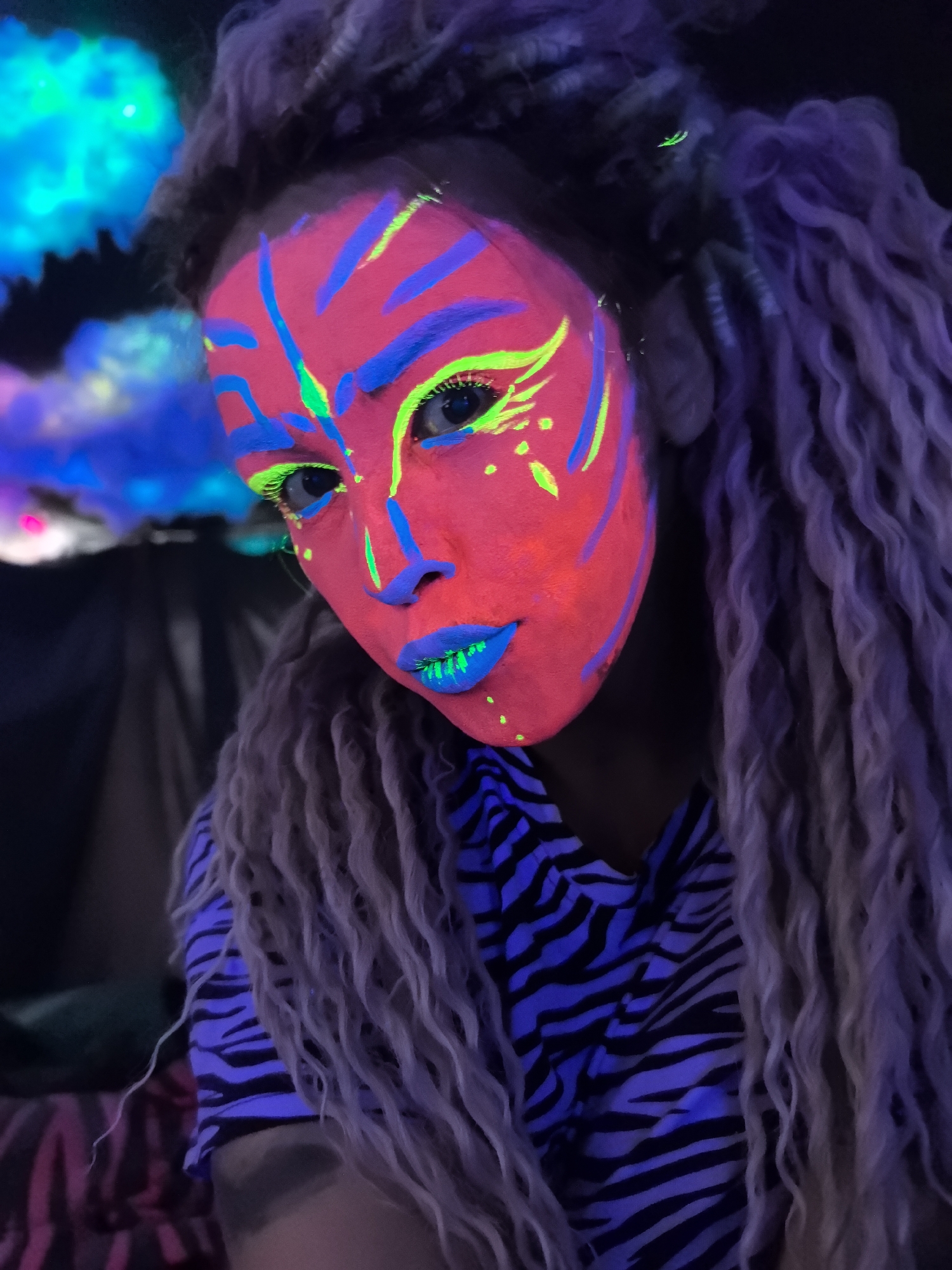 Artist documents neon makeup session with props in Noviy