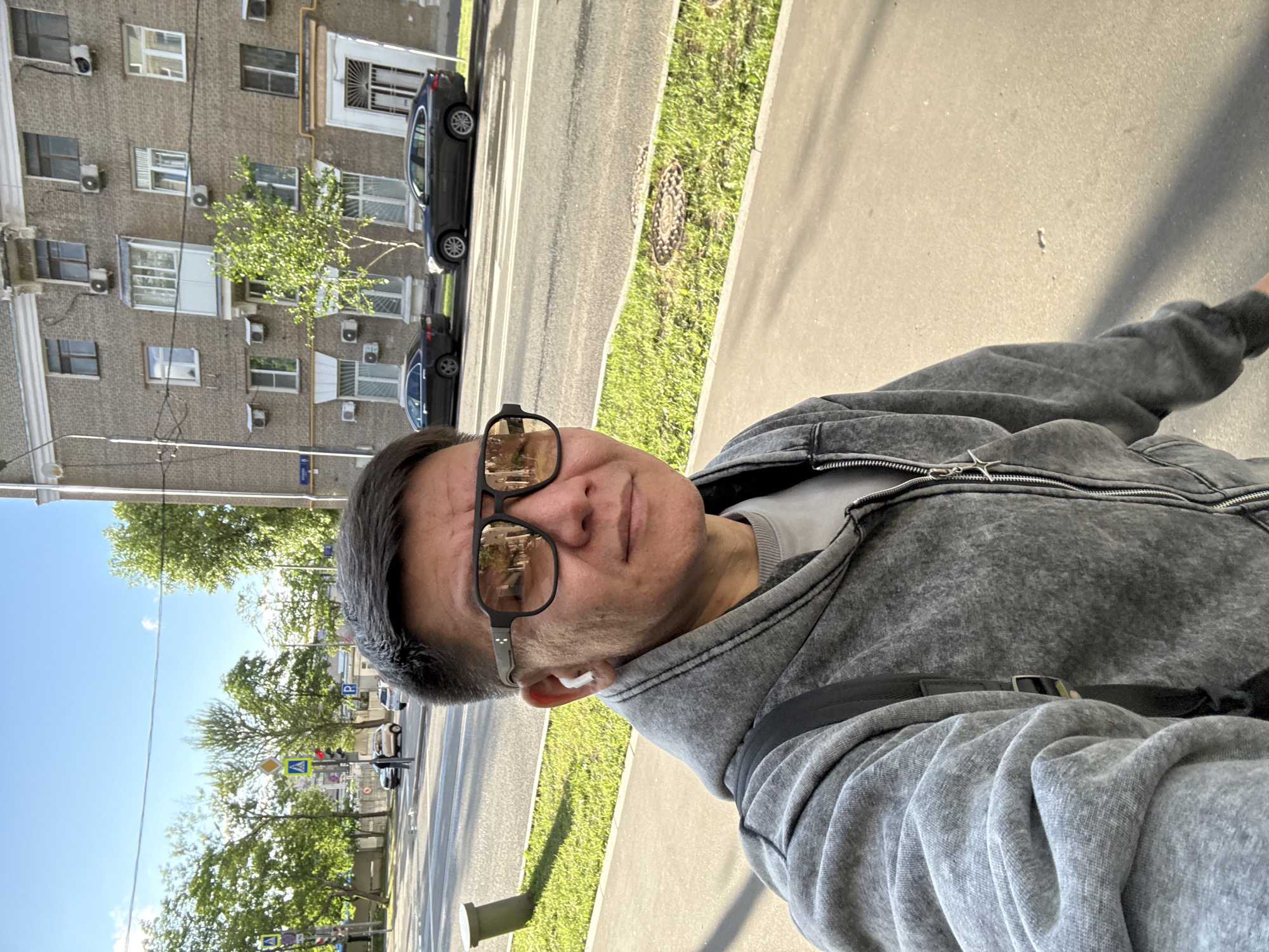 Street selfie in Moscow, sunglasses and earbuds on.