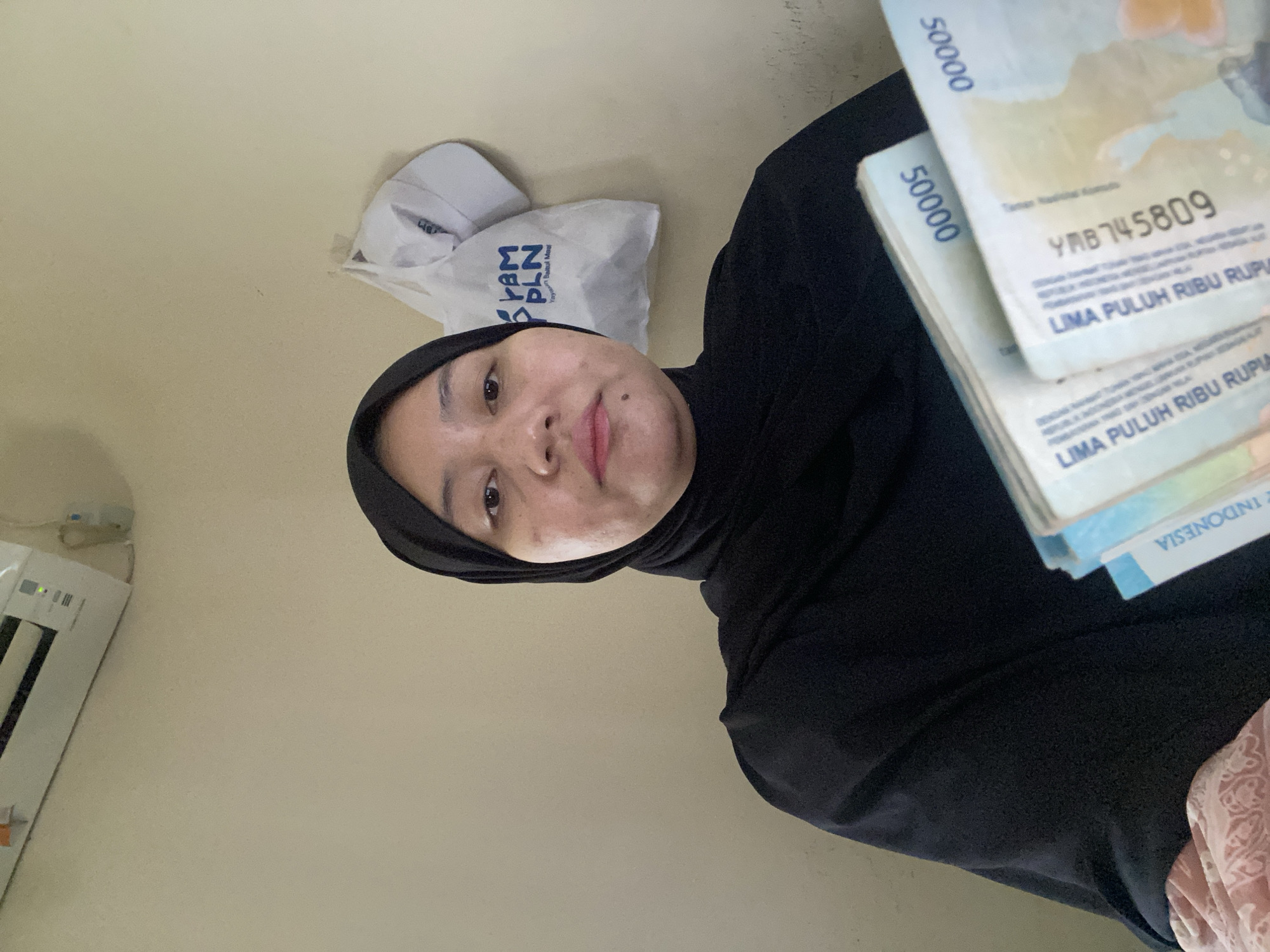 Cash and a printer: rupiah banknotes handled indoors in Banjarbaru