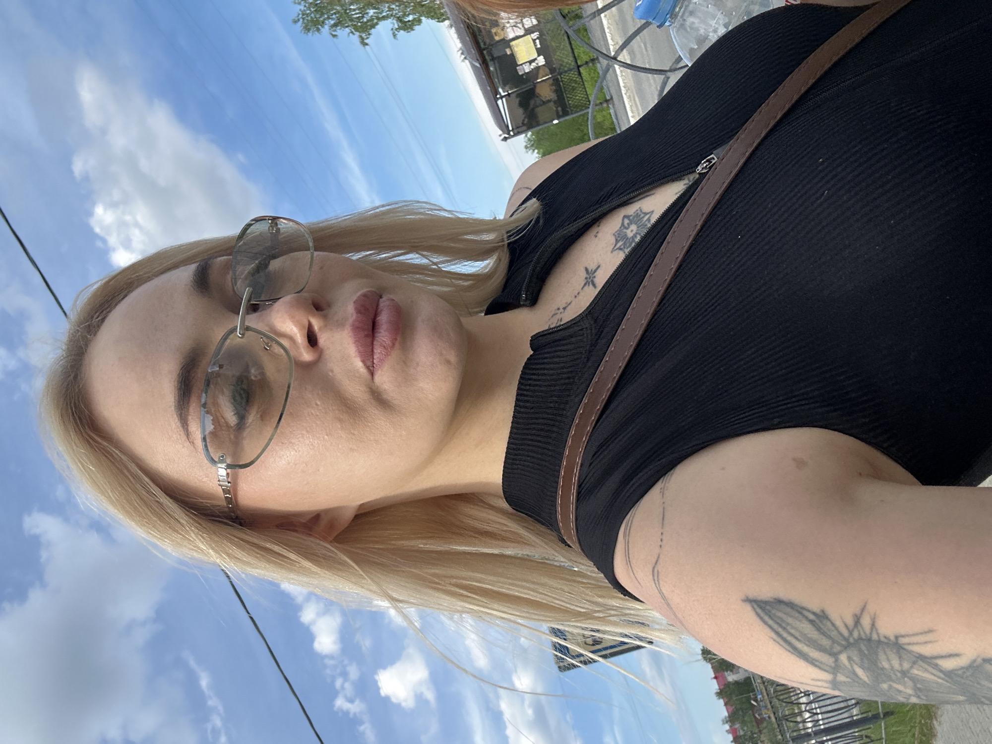 Woman takes selfies with lilac bouquet during outdoor walk
