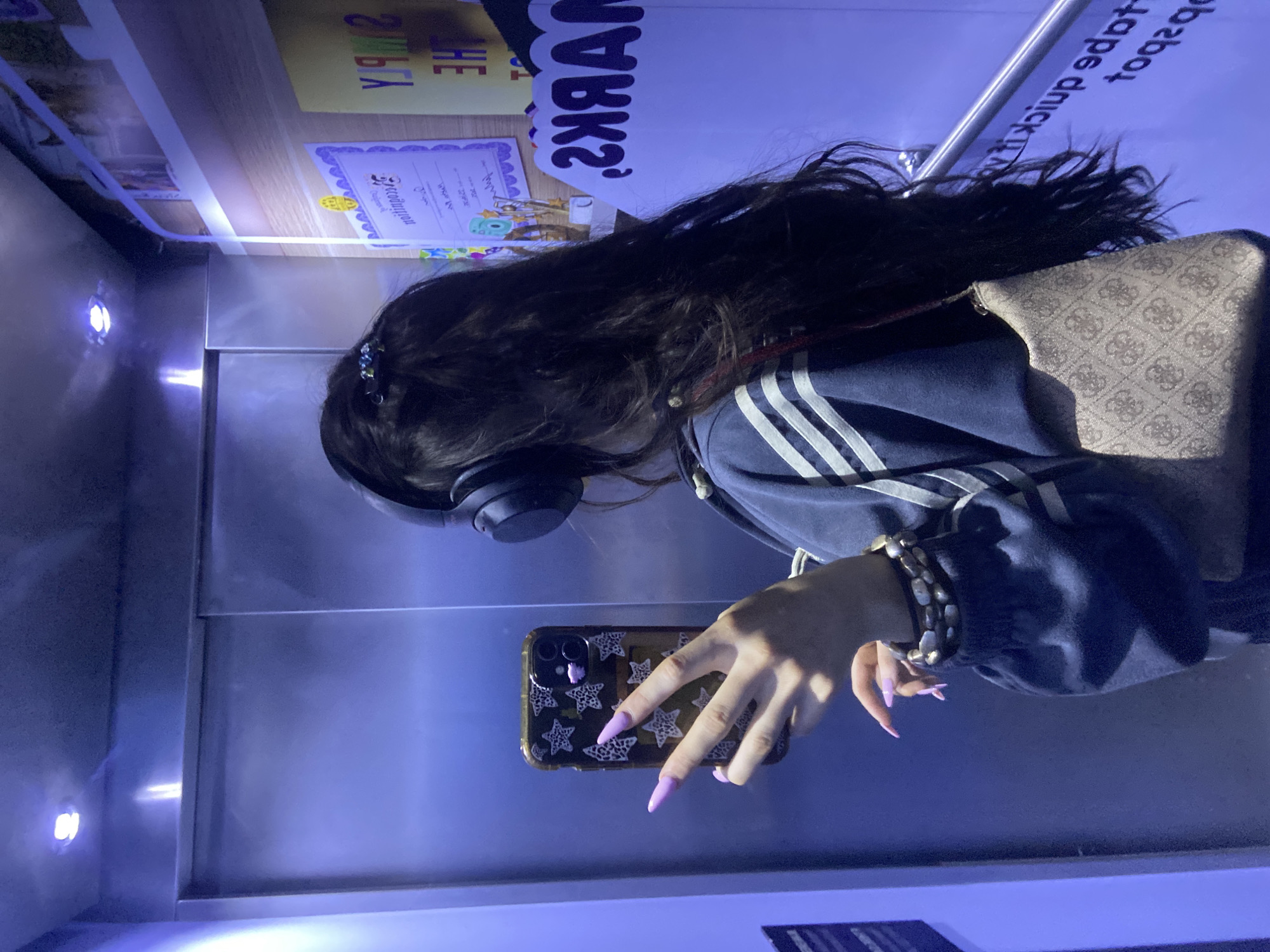 Woman in striped hoodie rides elevator with headphones