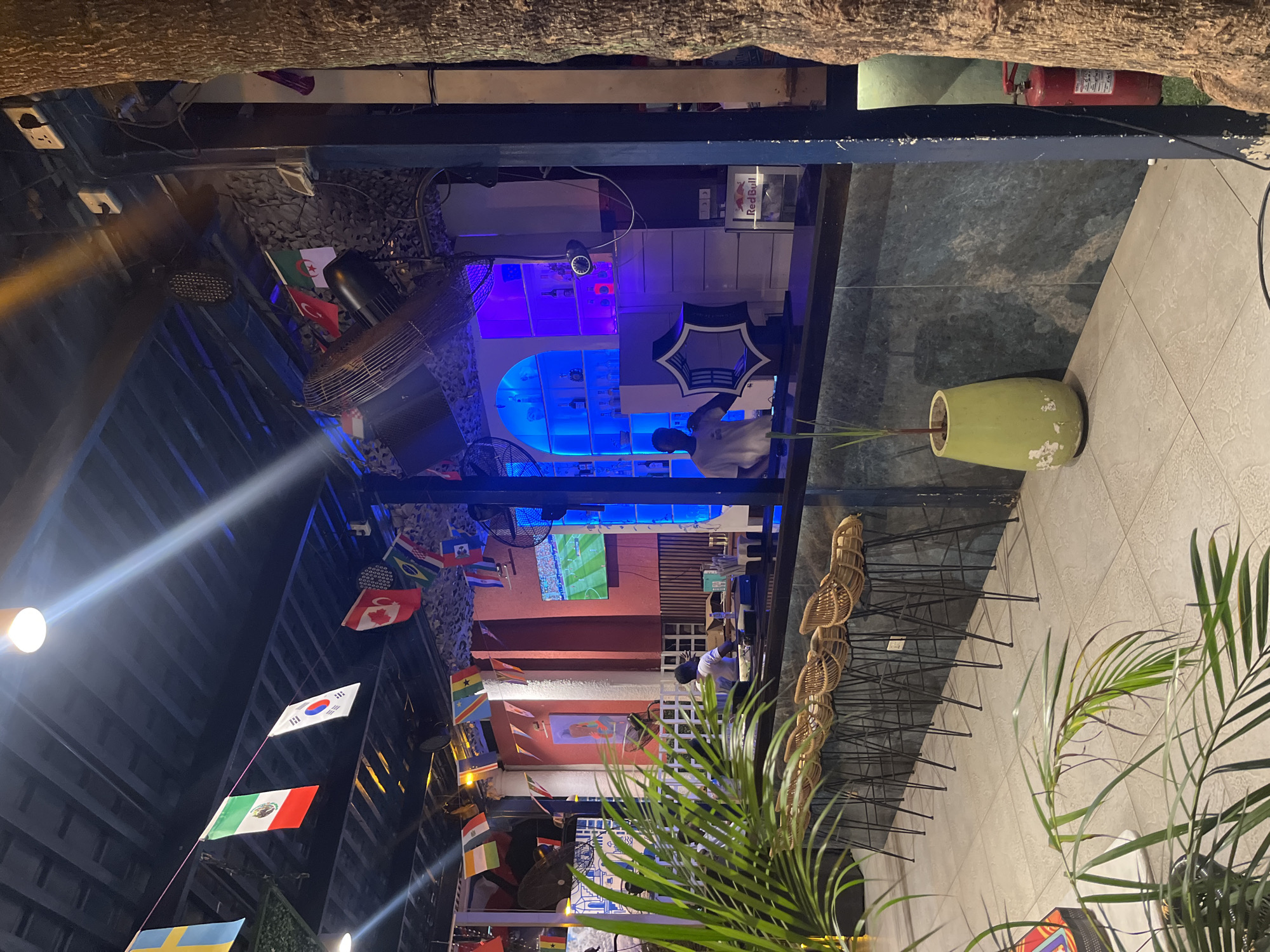 Accra bar venue with flags, neon art, and international flair