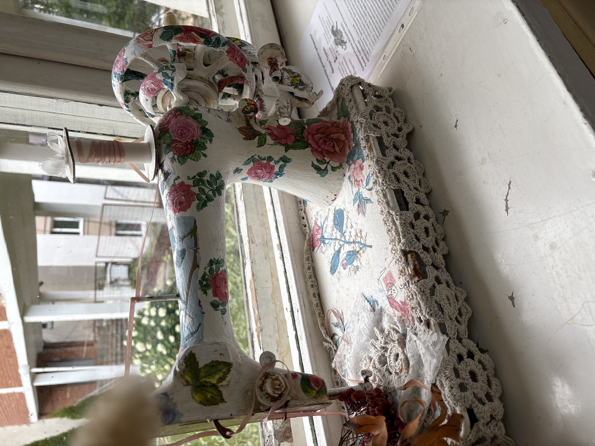 Floral-painted decorative sewing machine on a Vitsebsk windowsill