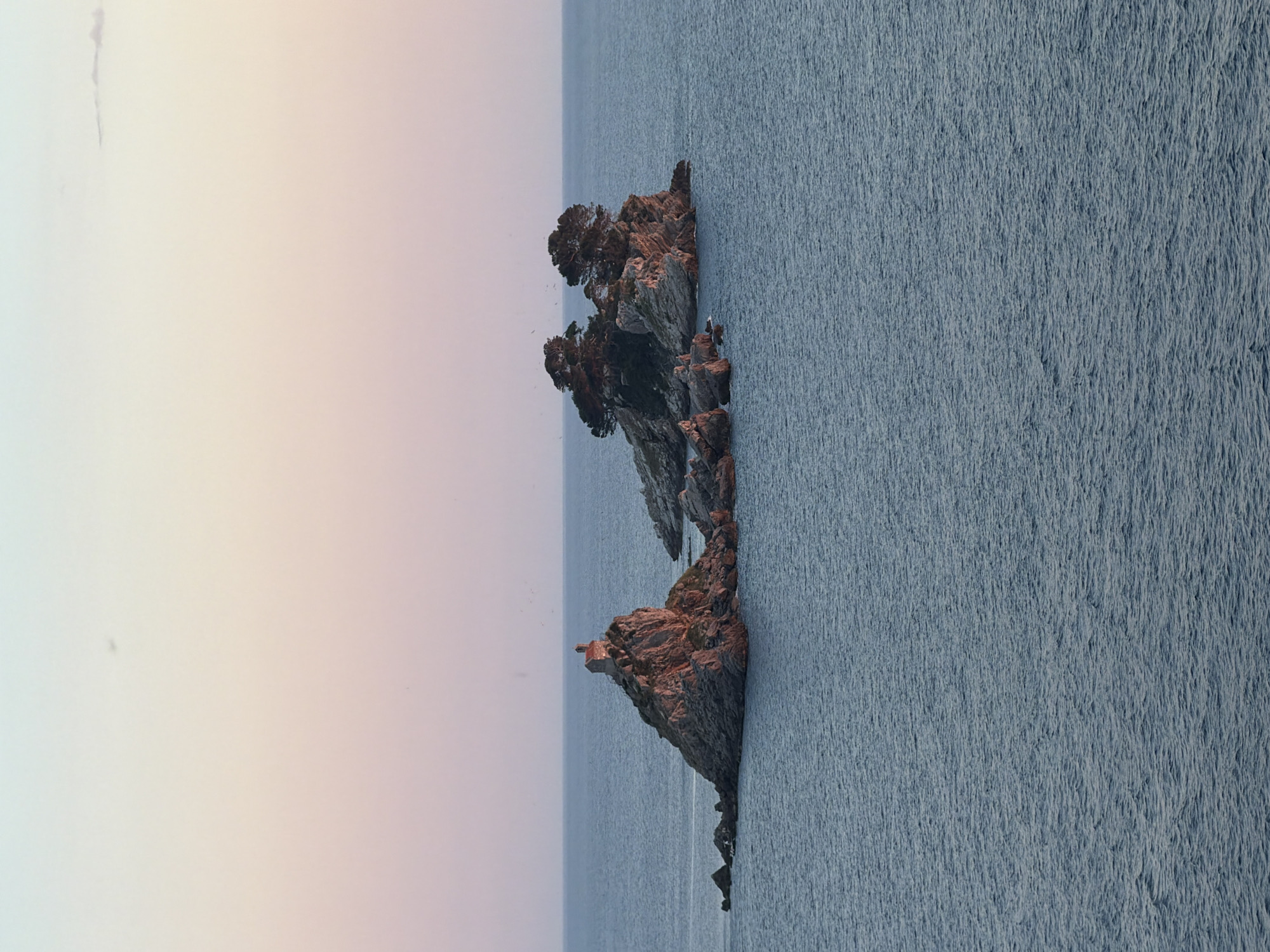 Rocky islet observed off Montenegro coast during evening hours