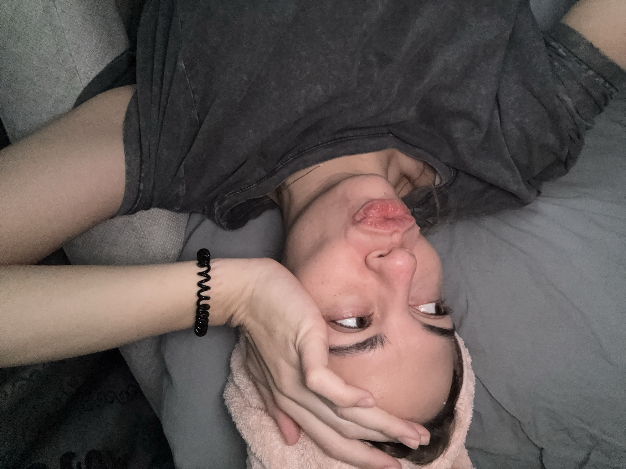 Woman rests on bed with towel in Ust-Ilimsk
