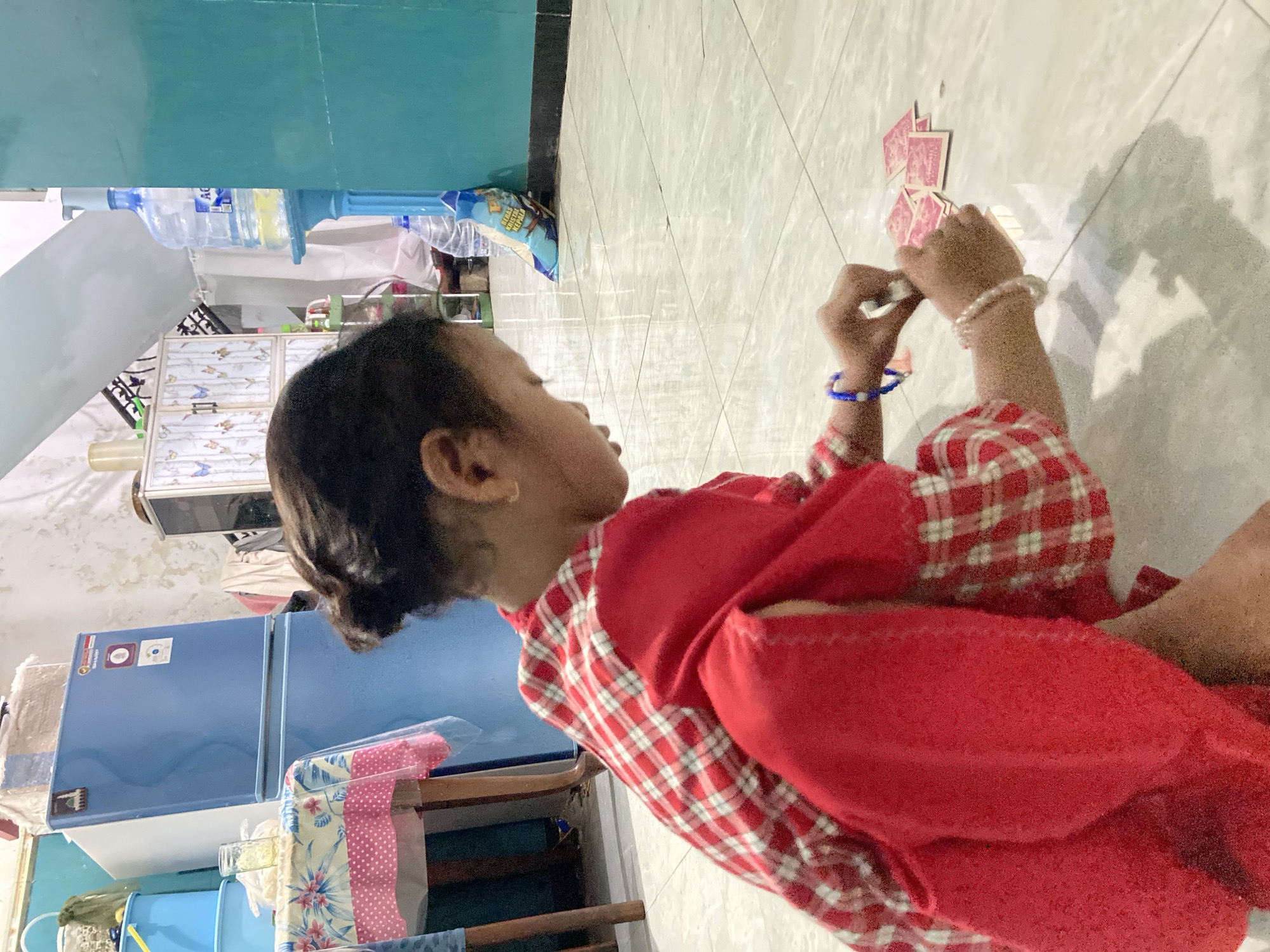 Child plays with cards at home in Gelam