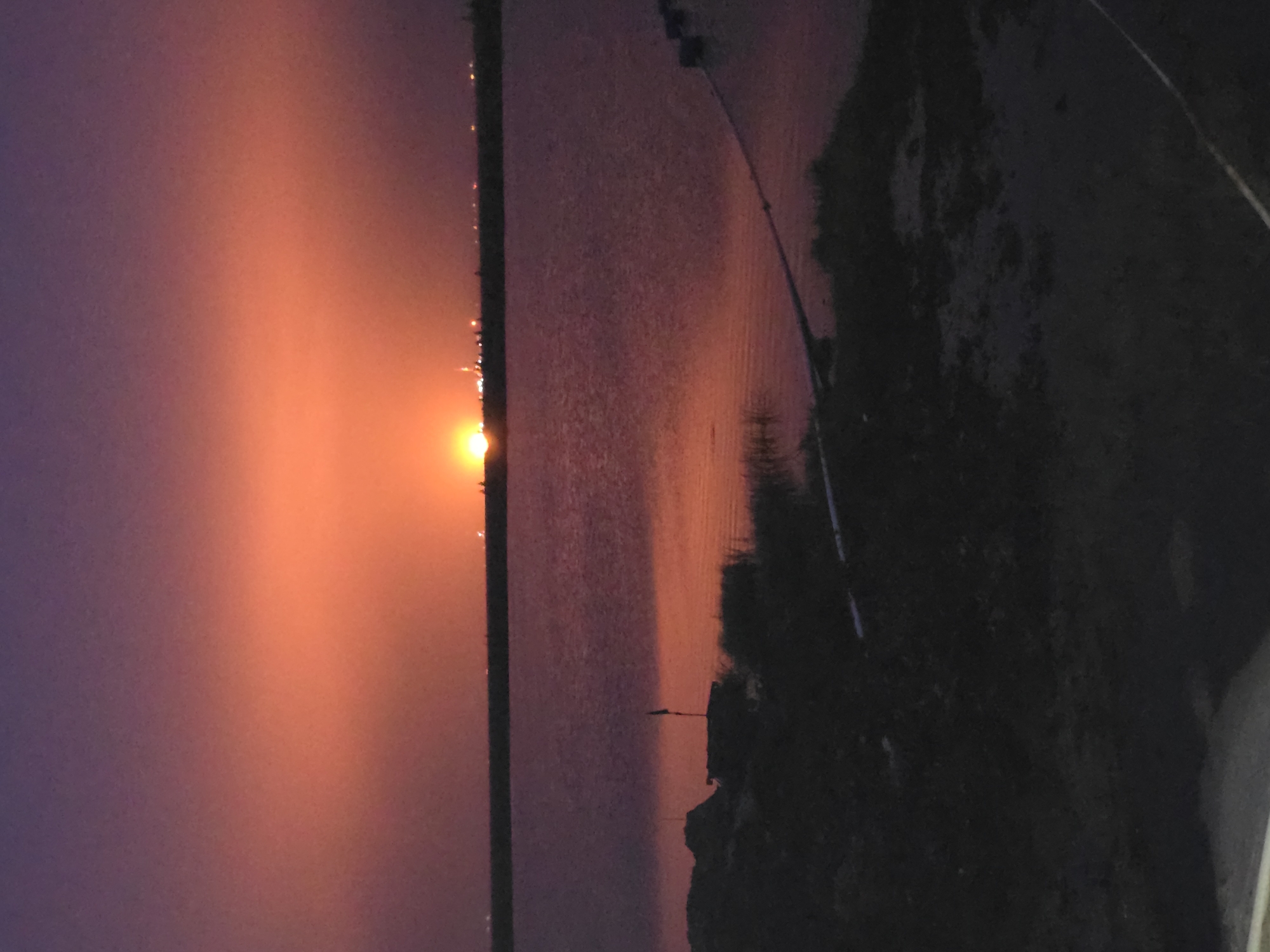 Sunset over water, sky shifting purple to orange
