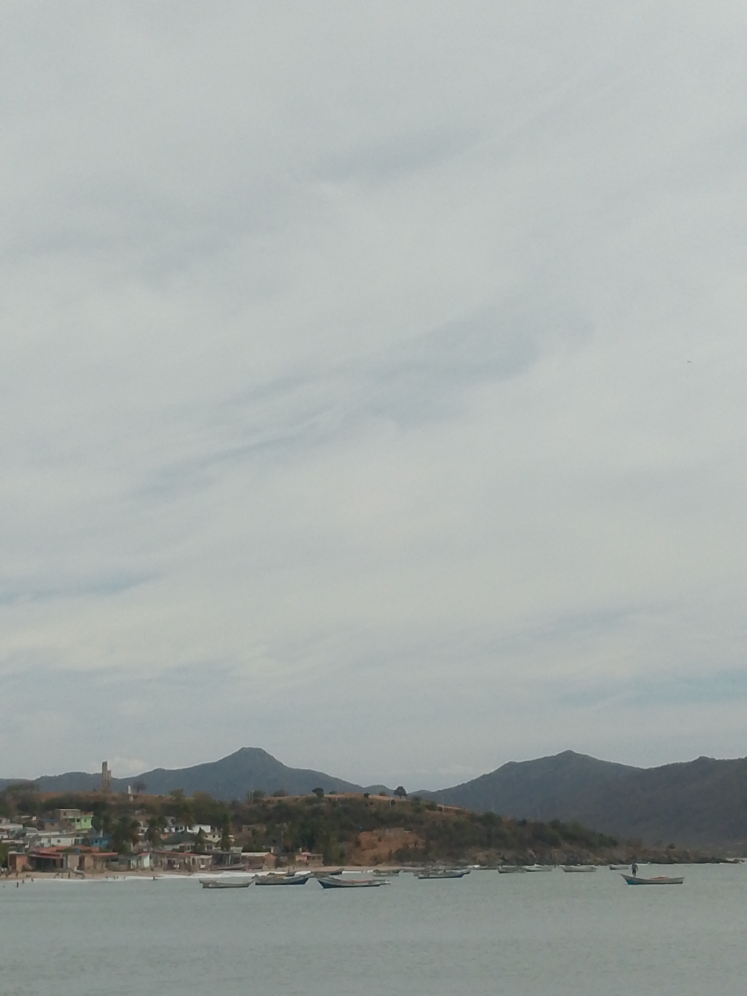 Busy afternoon at Juan Griego beach under cloudy skies