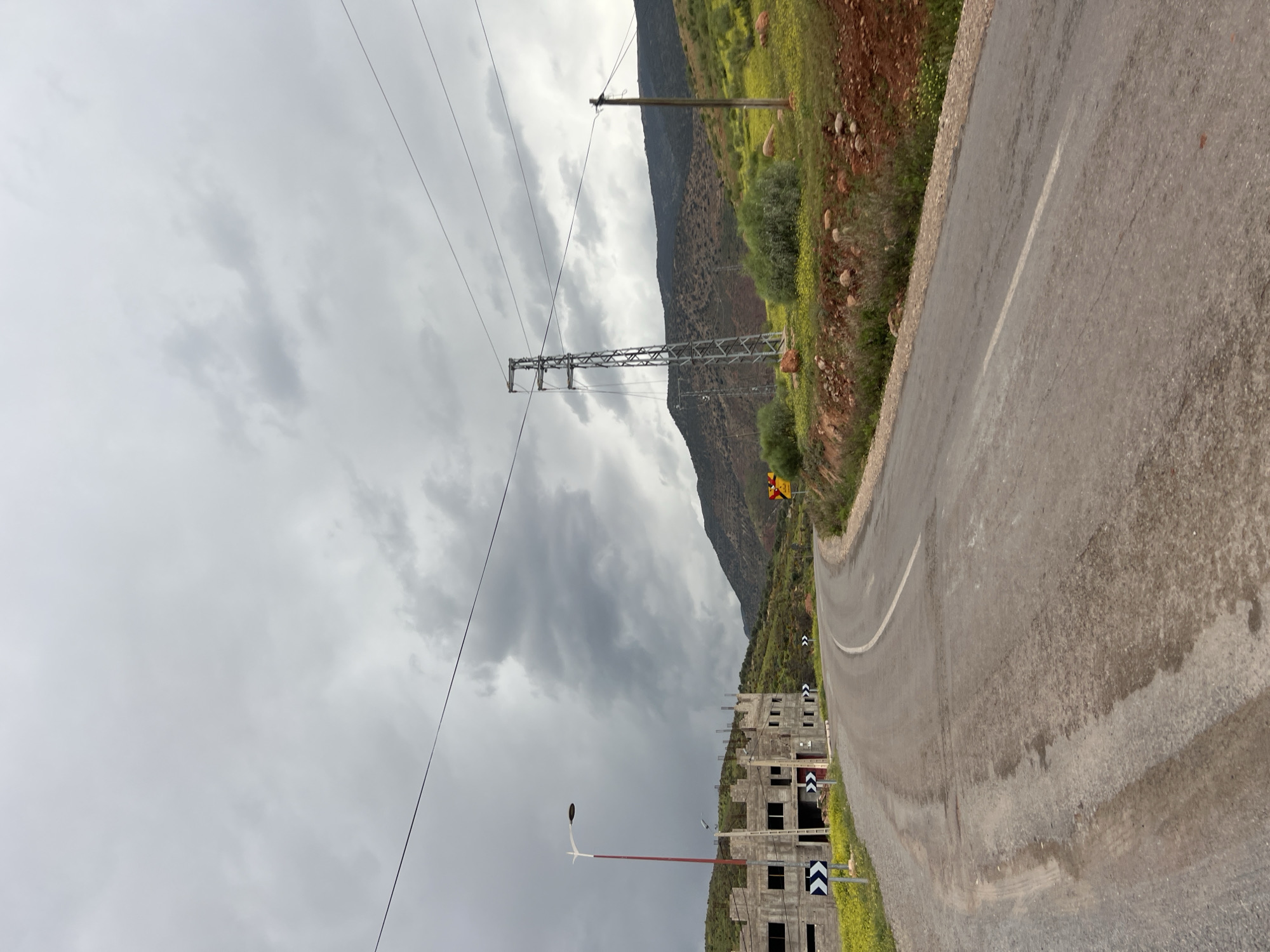 Drive through Ouaouizert reveals roadside construction, overcast skies