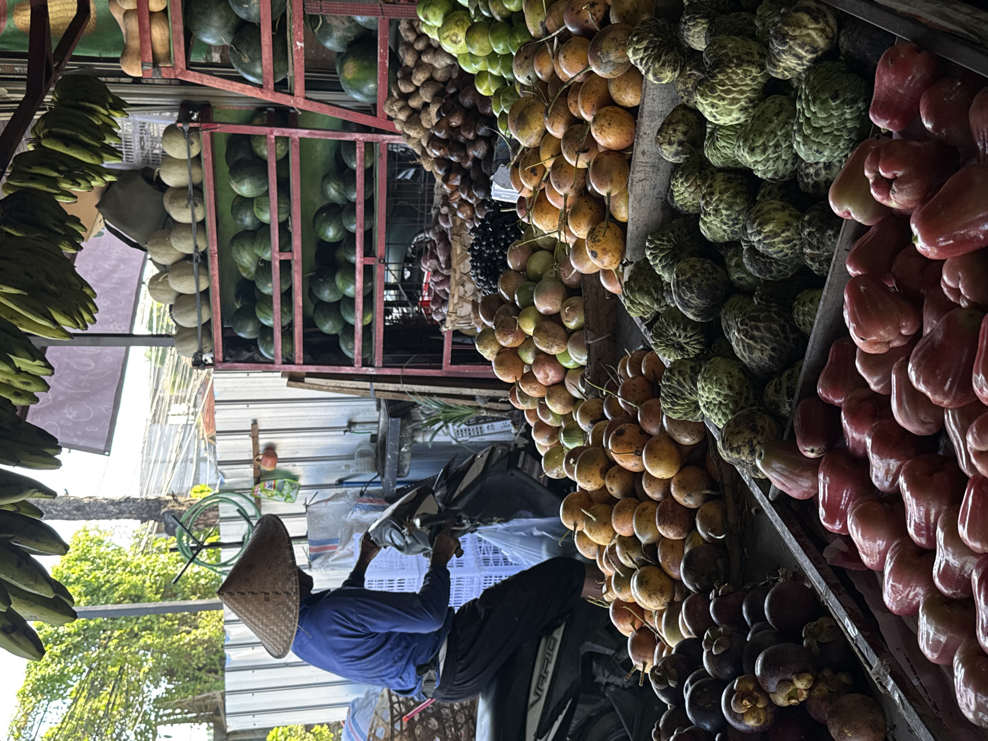 Vendor serves customers at North Kuta fruit stall