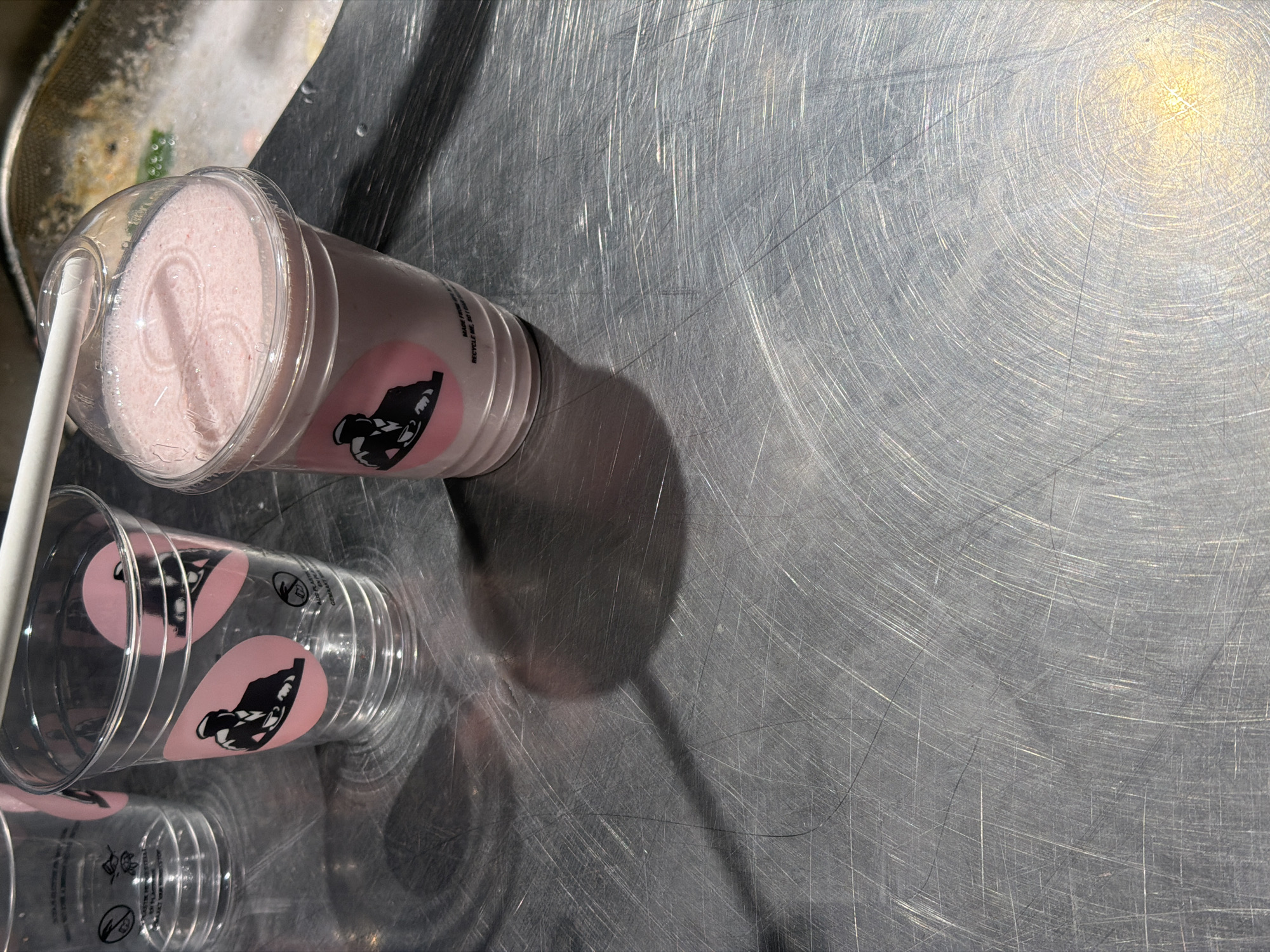 Pink drink photographed with empty cups in Paris