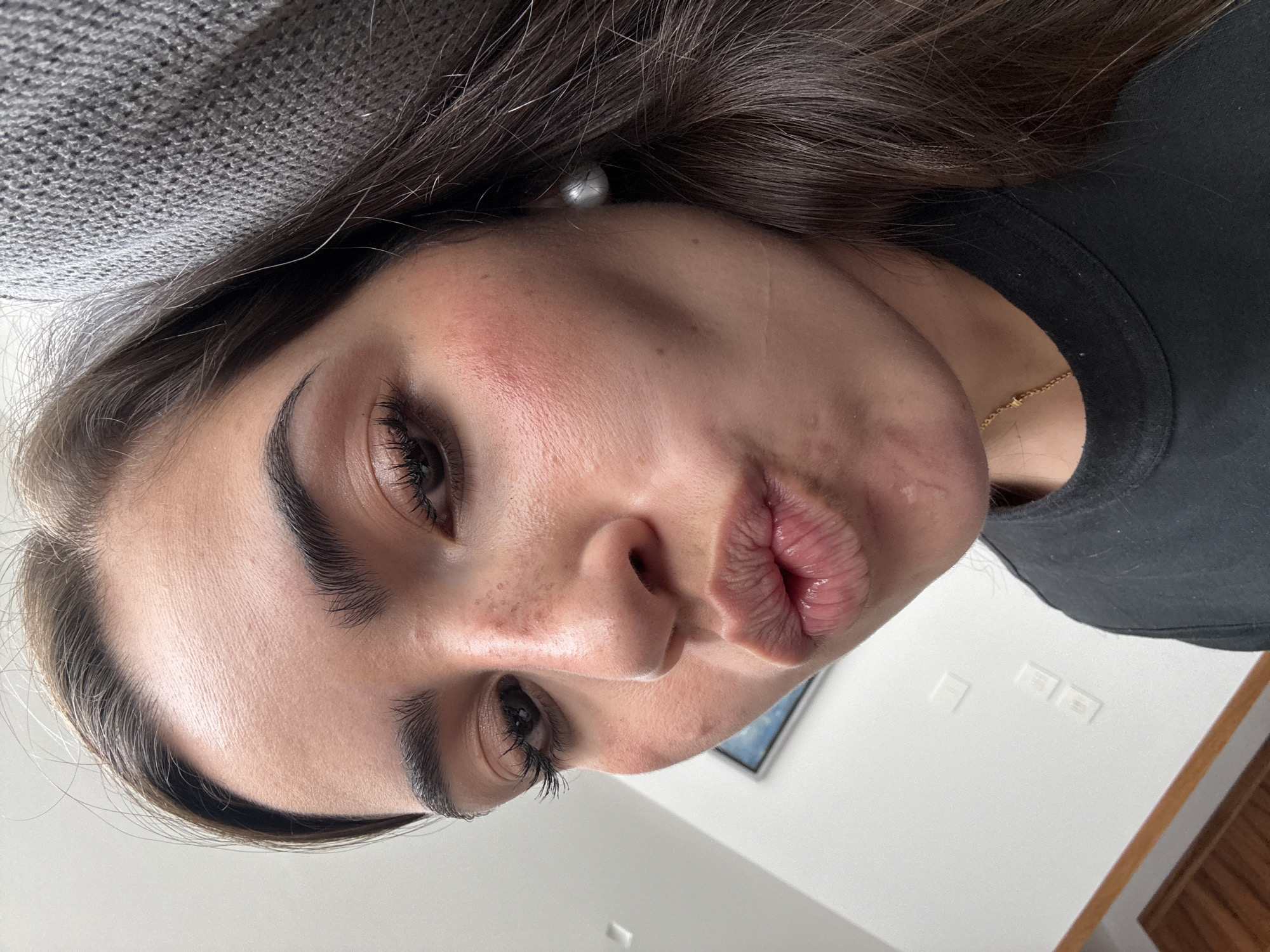Woman takes selfie while someone uses laptop in Mexico
