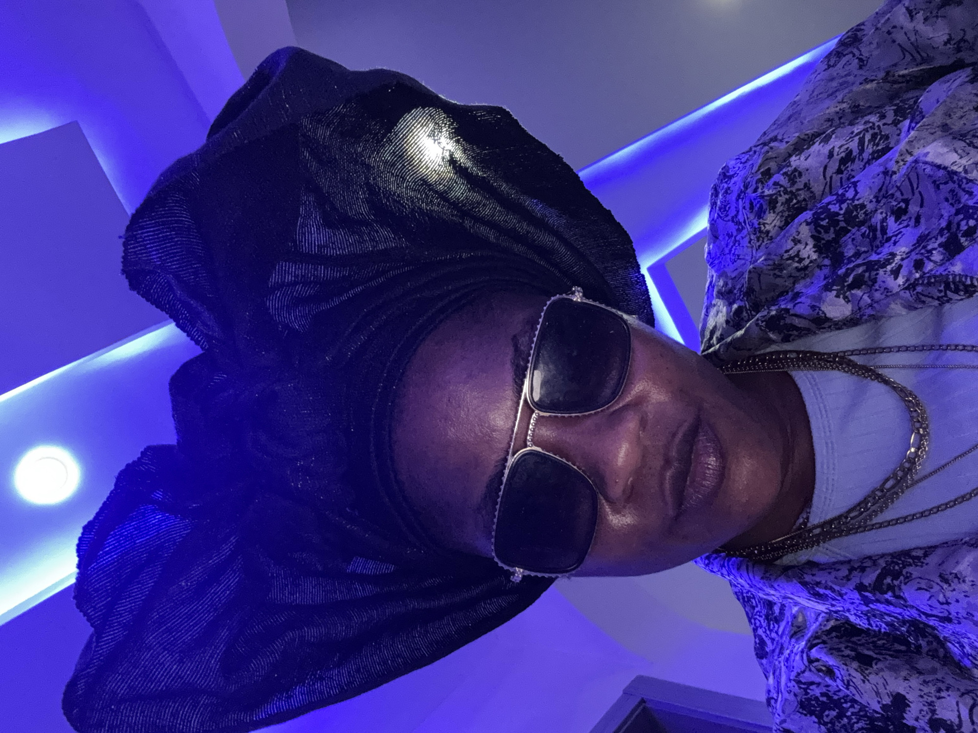 Dressed up and posing in Ajara, Nigeria, blue lights and gold jewelry