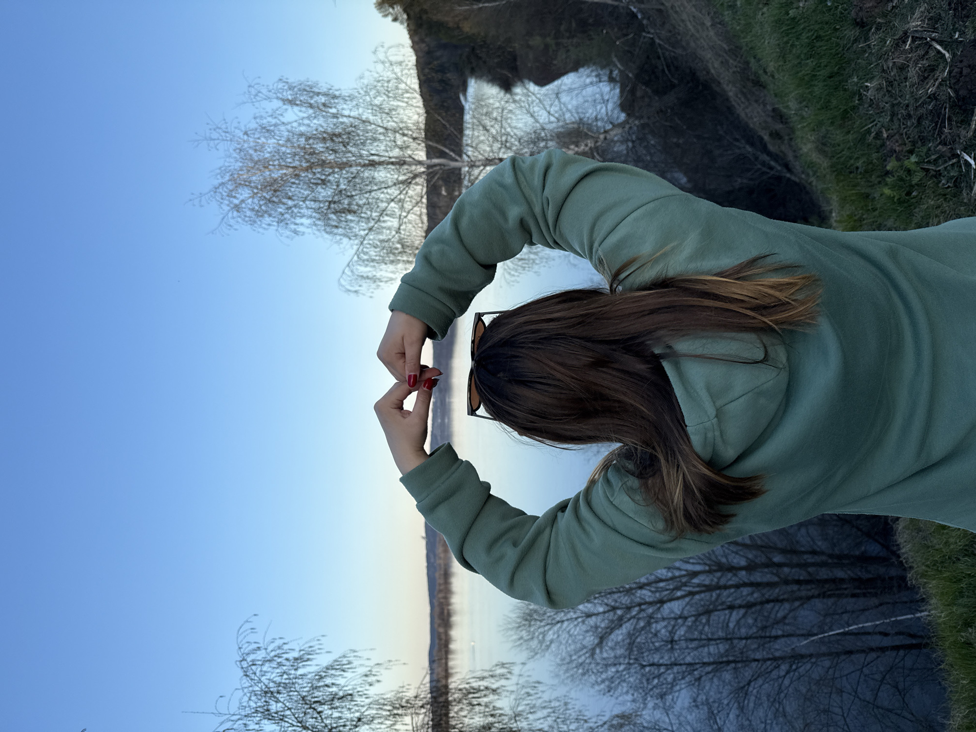 Person makes heart gesture at waterside in Chernushka, Russia