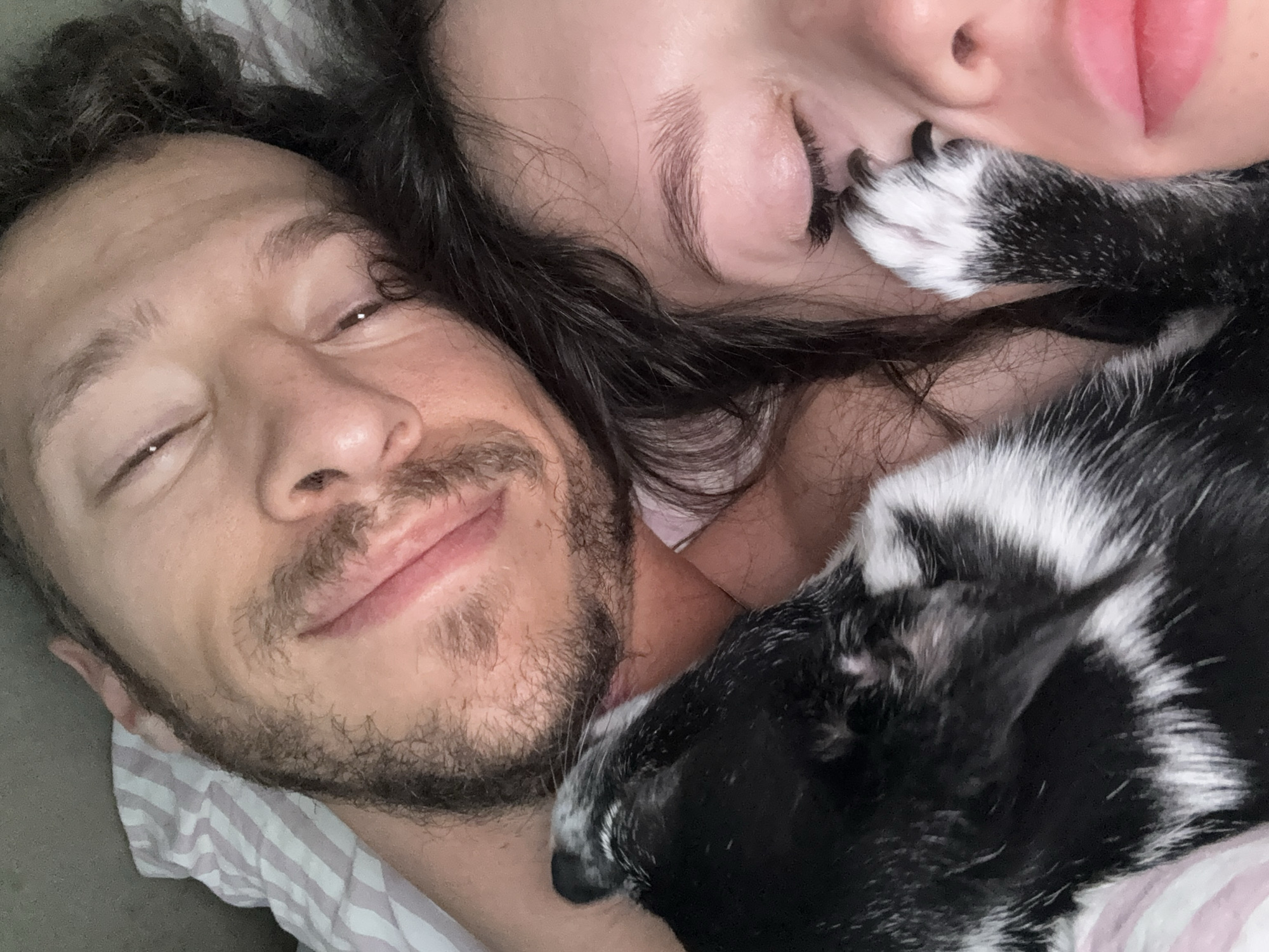 Two people, dog rest together indoors in early morning