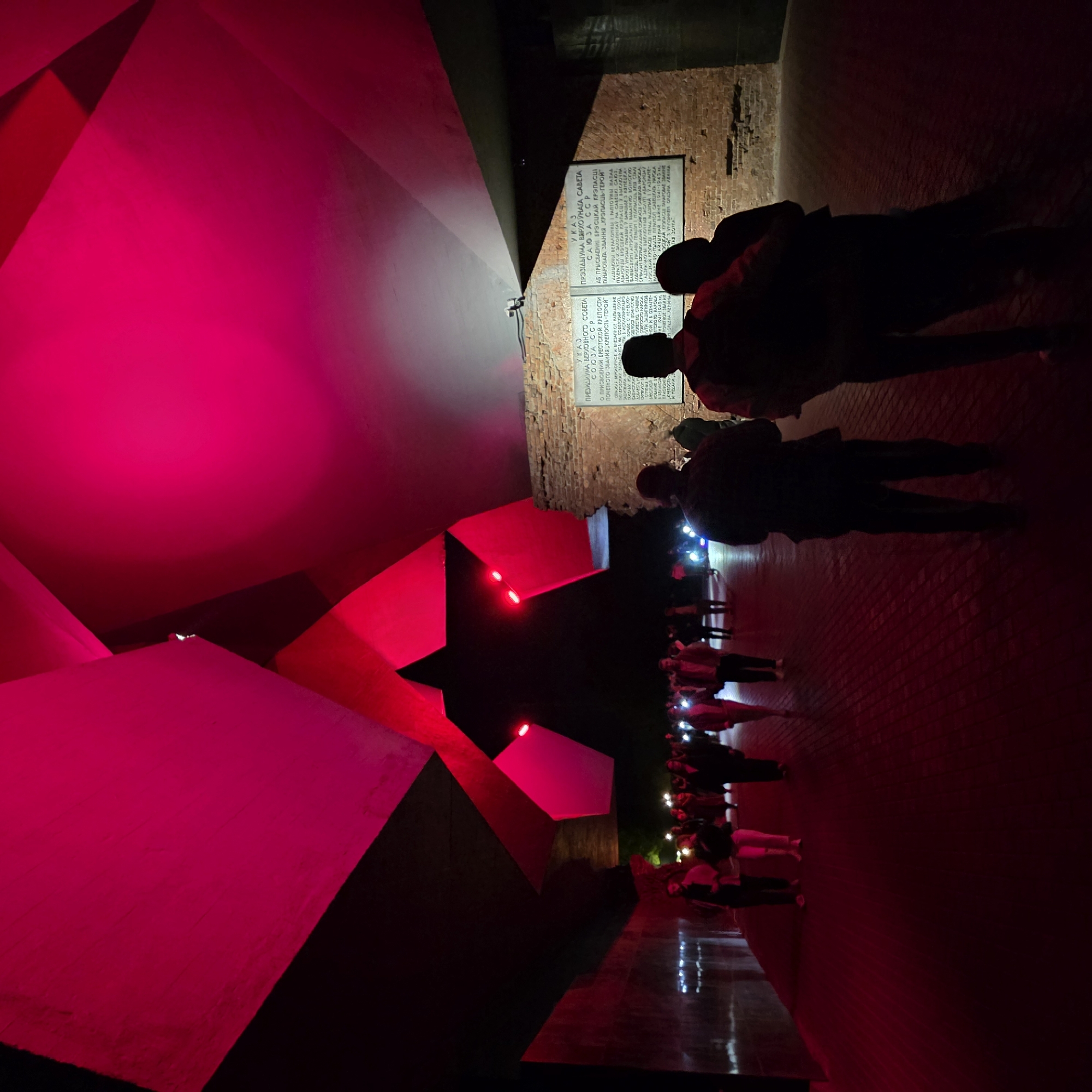 Evening visitors gather at illuminated Brest Fortress red star monument