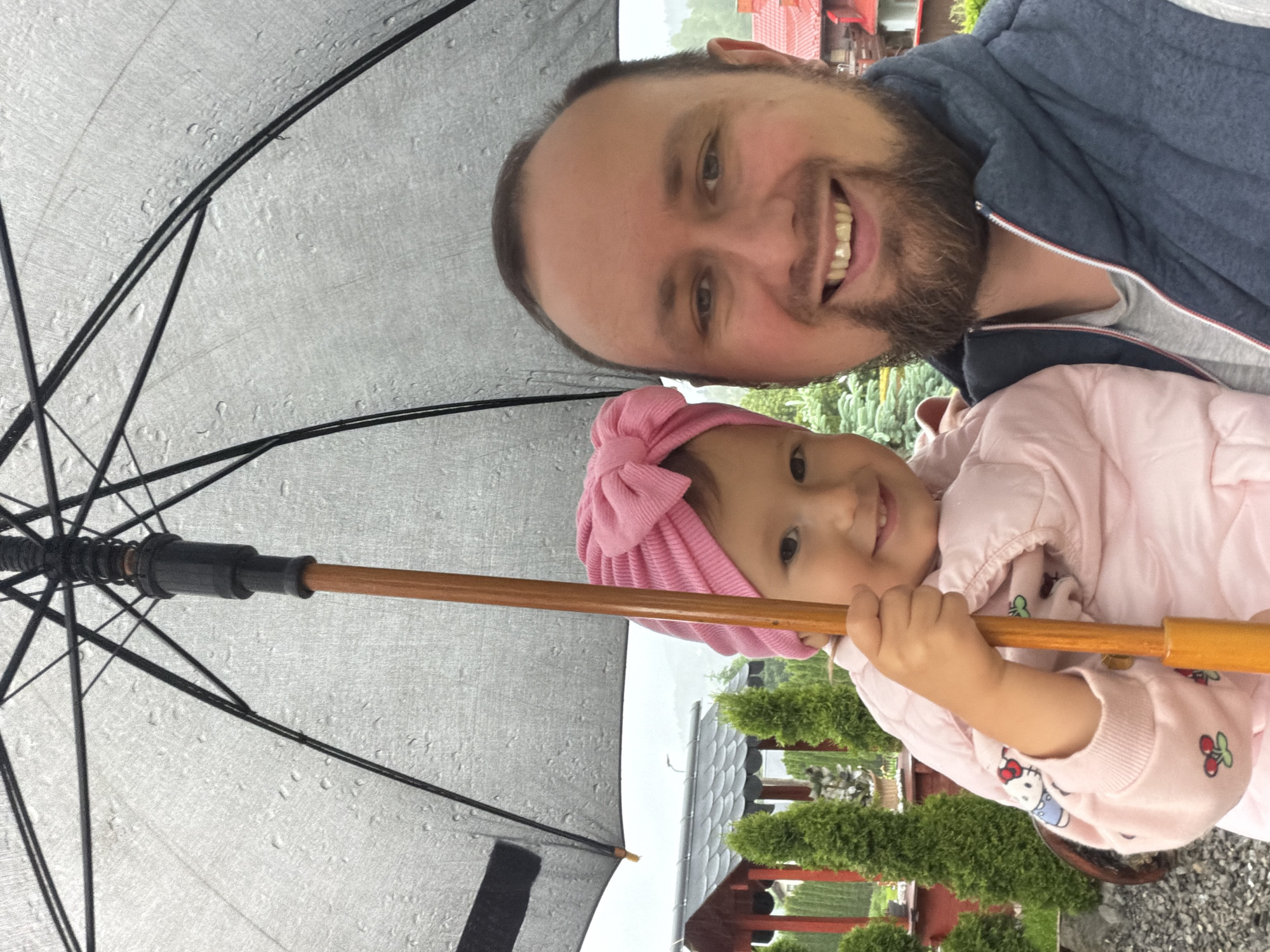 Father and child share umbrella selfie moment in Wisła