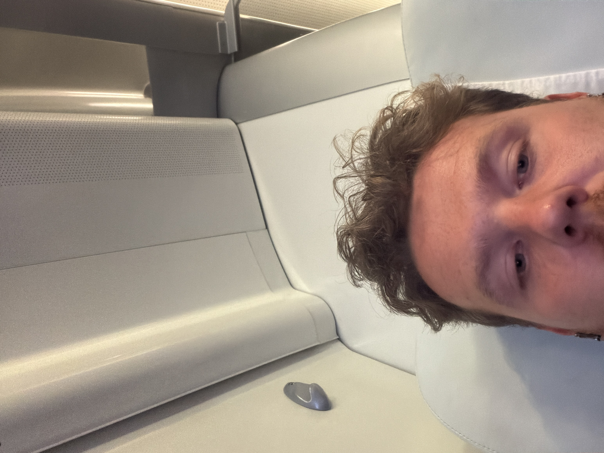 Man takes selfie in modern transport compartment, Milton Keynes