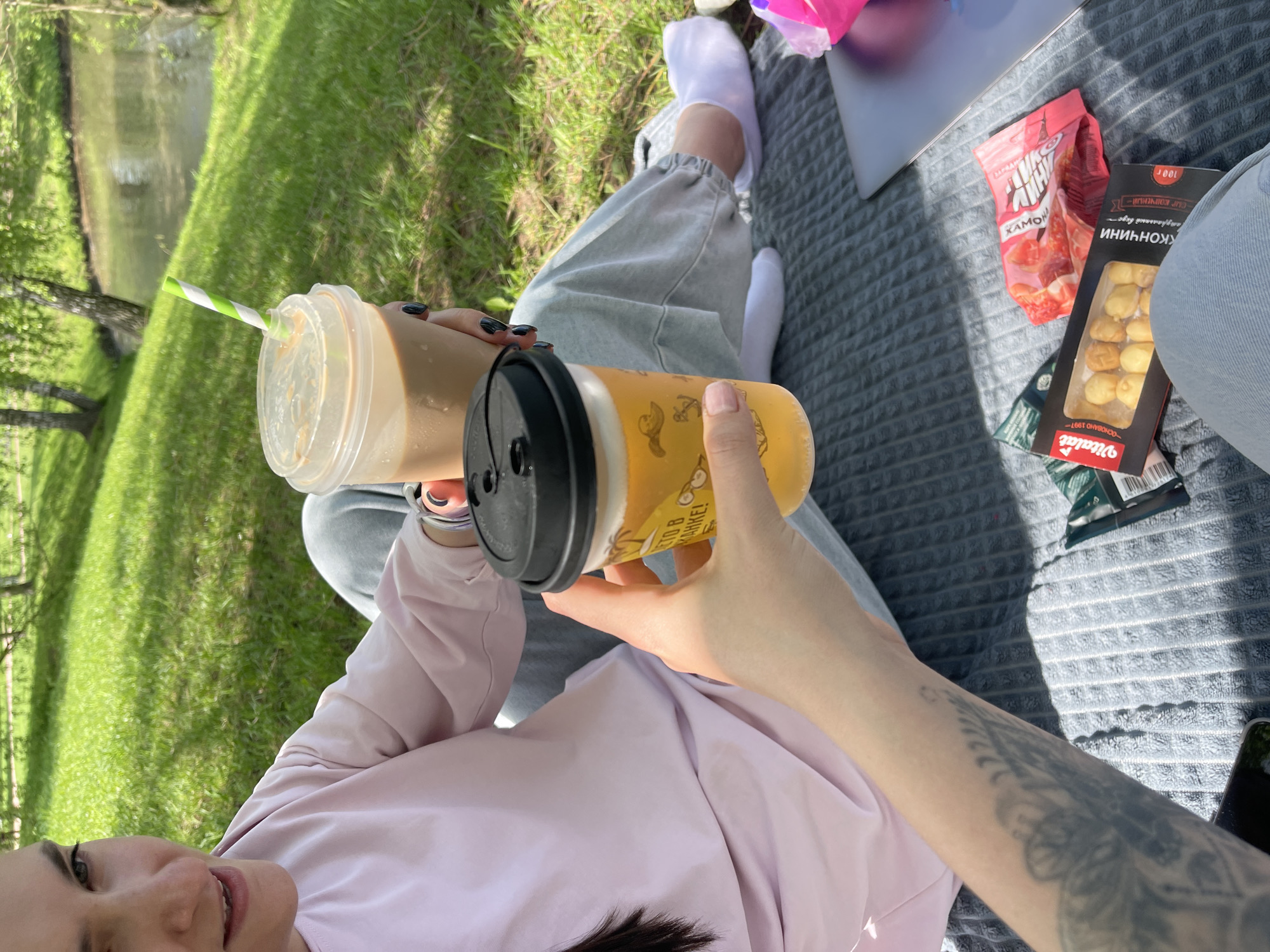 Moscow parkgoer enjoys morning picnic by water with beverages