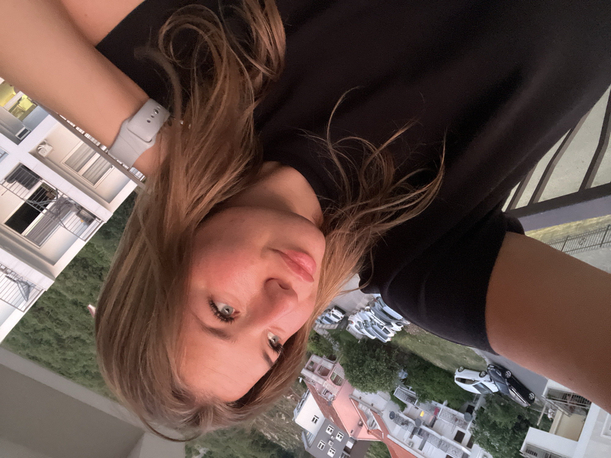 Woman films selfies at dusk from Budva balcony