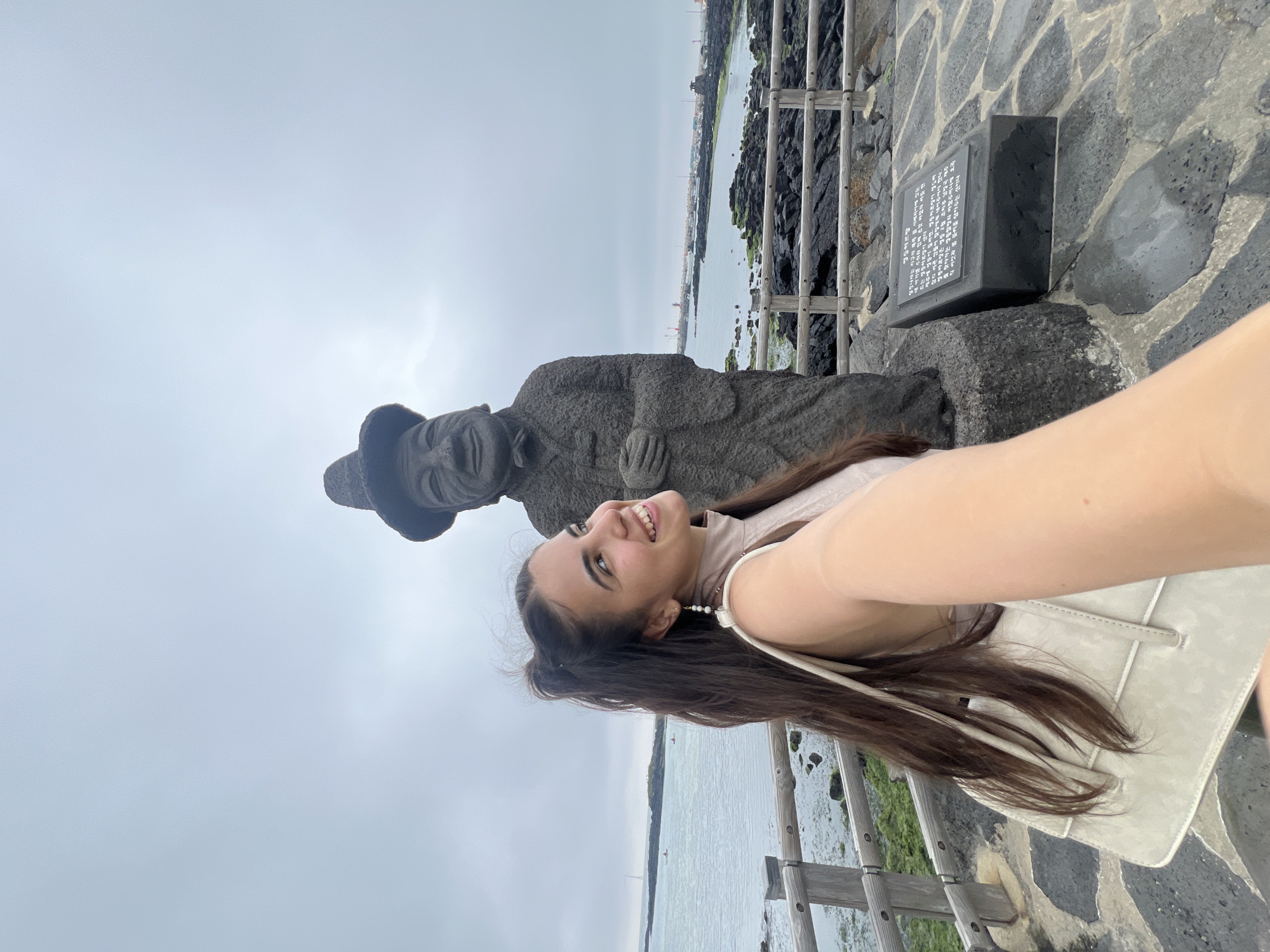 Tourist takes selfies with statue on Jeju Island