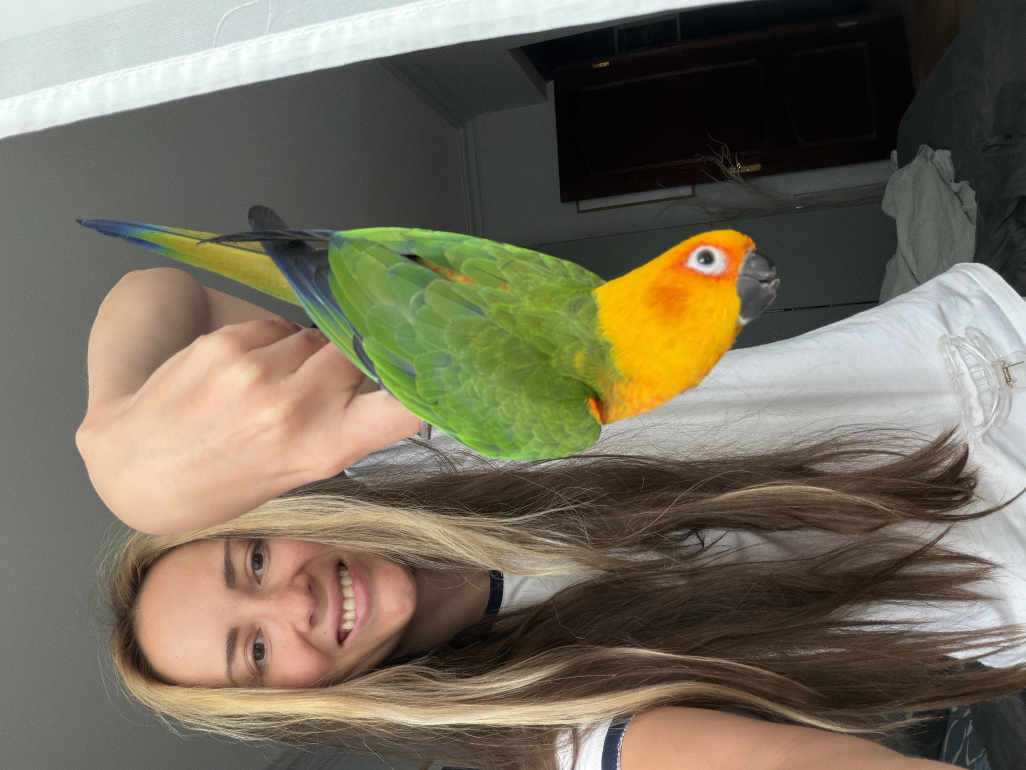 Woman and child play with colorful parrot in Khimki