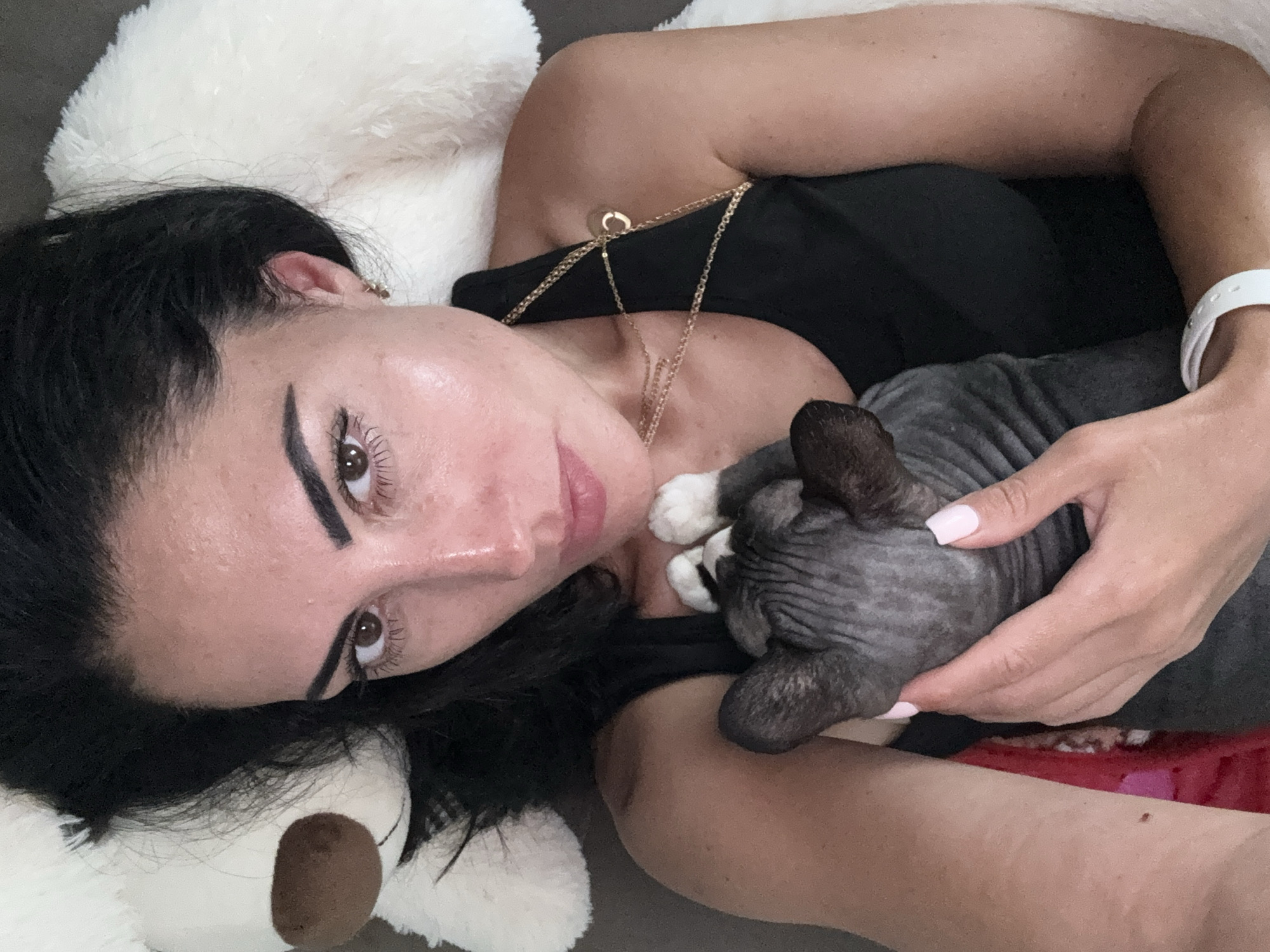 Woman relaxes indoors with Sphynx cat in Netanya