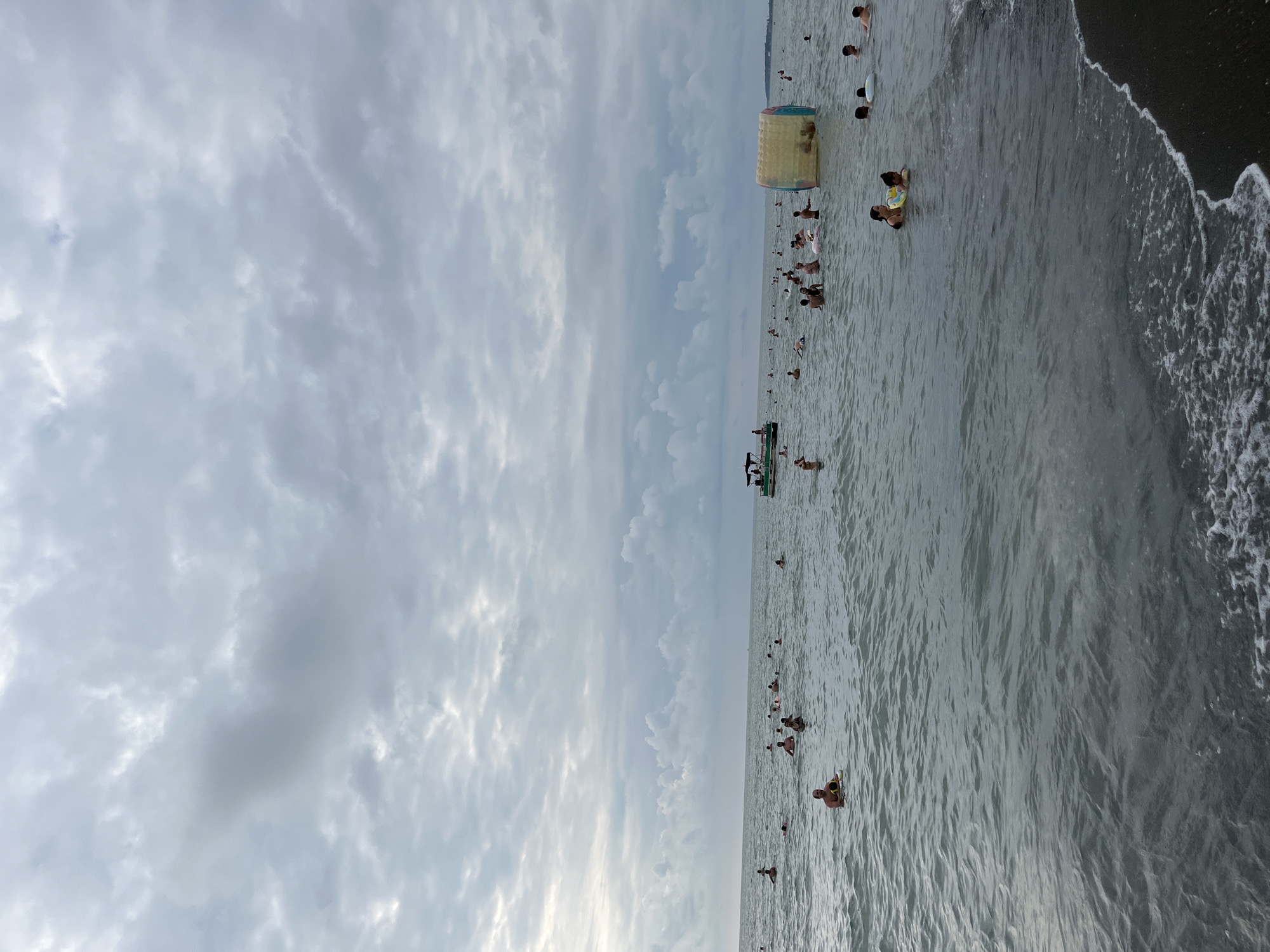 Crowded summer day at Ureki's Black Sea black sand beach