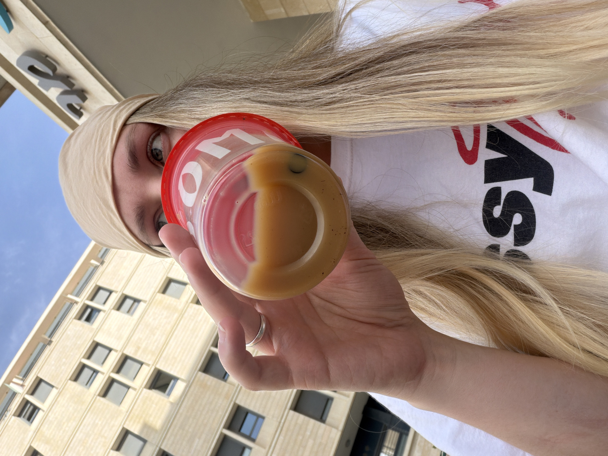 Woman enjoys layered drink outdoors in Tel-Aviv