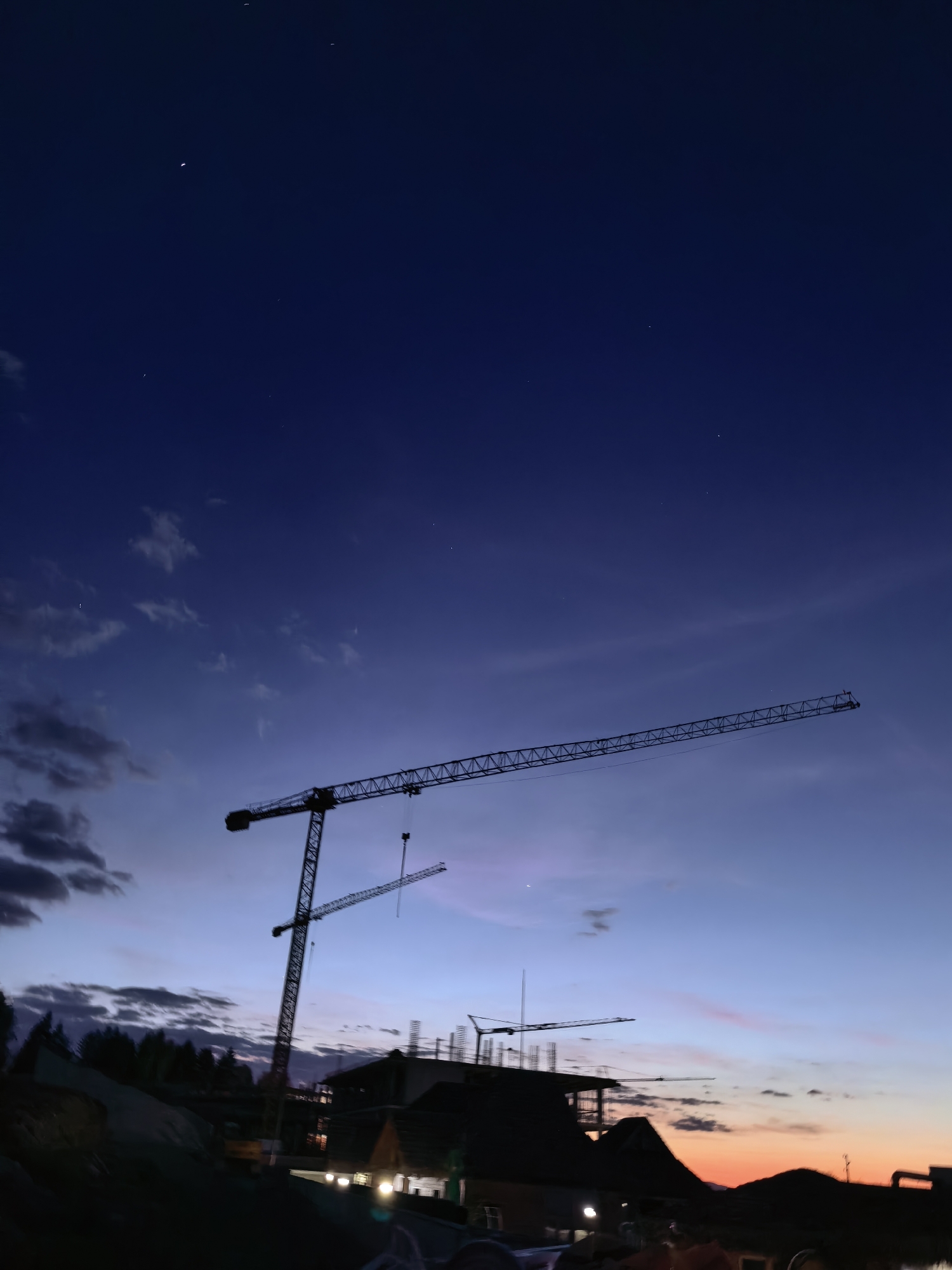 Construction cranes silhouetted at dusk in Sapareva Banya, Bulgaria