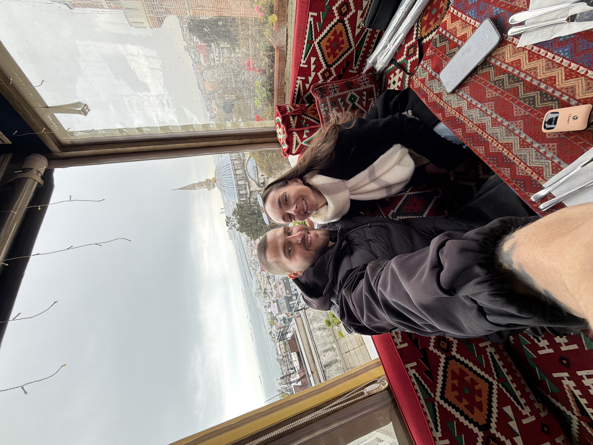 Tourists photograph overcast Istanbul skyline from elevated viewpoint