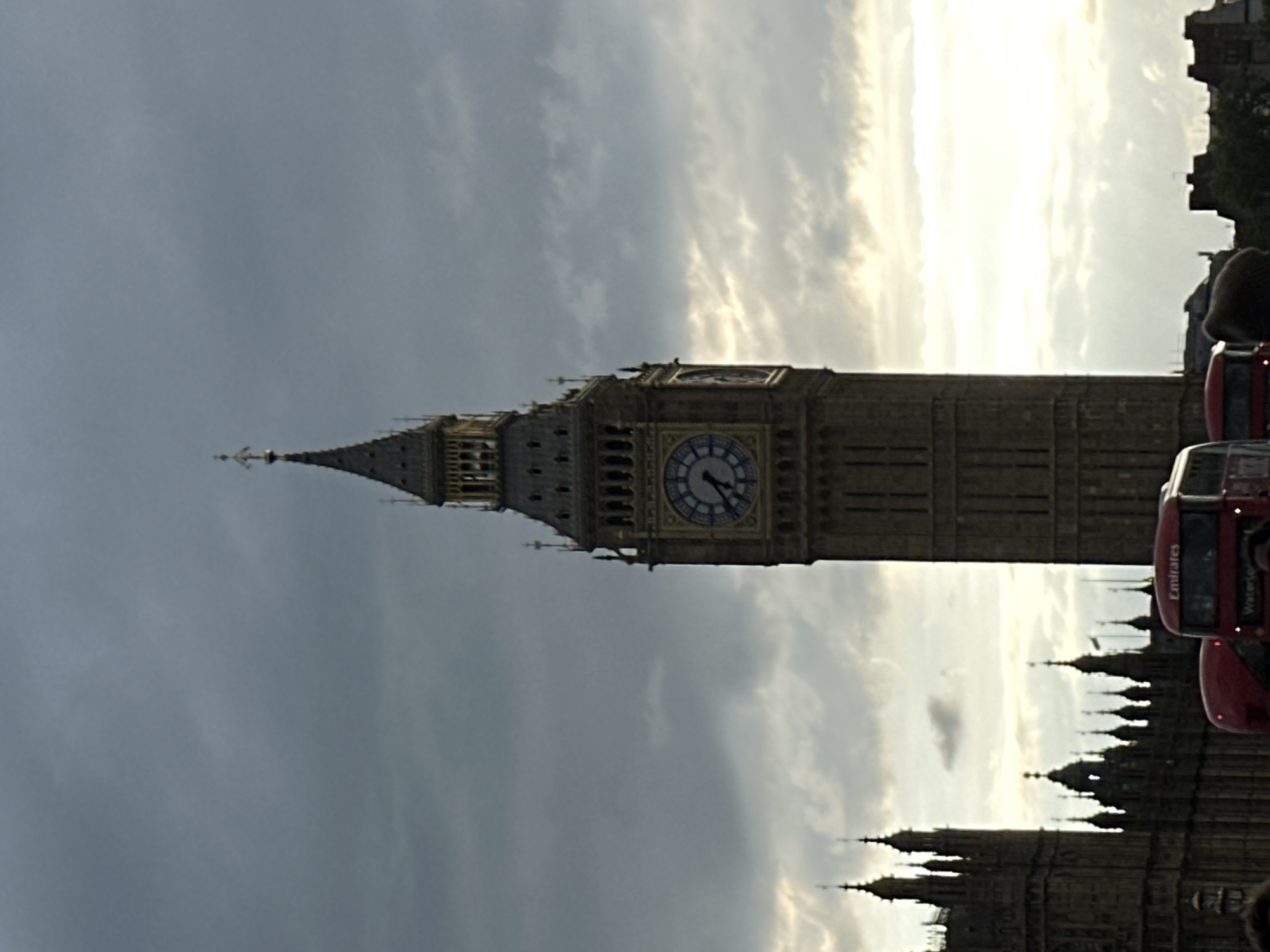 Red bus spotted near Big Ben under overcast London sky