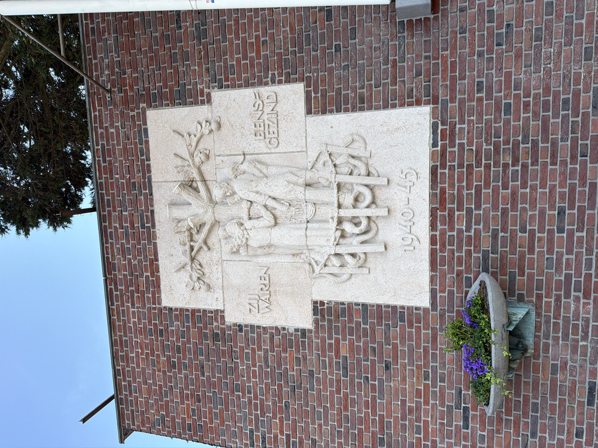 Brick facade relief sculpture in The Hague features tree and figures