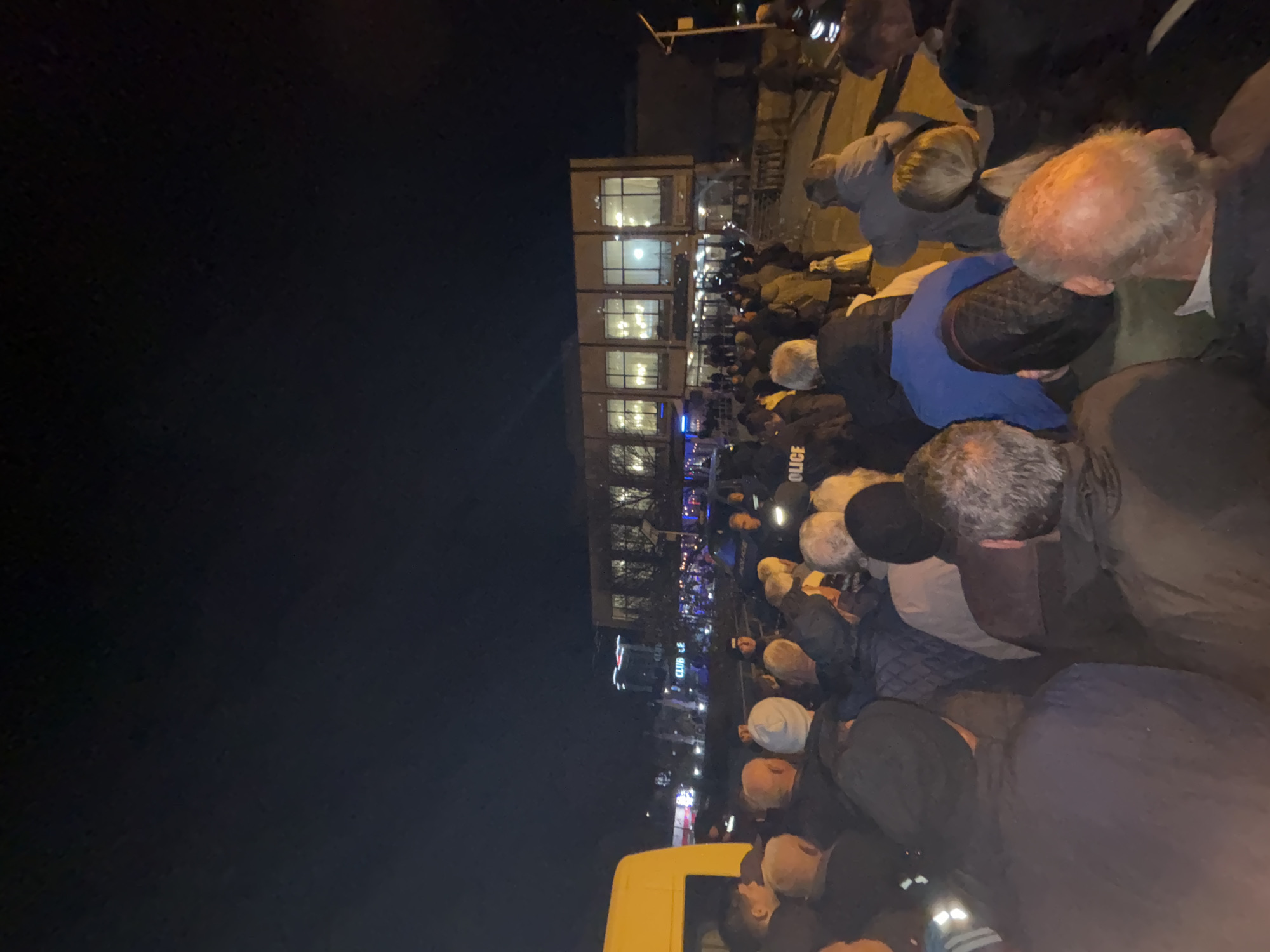 Nighttime crowd gathers outside building in Kardzhali, police present