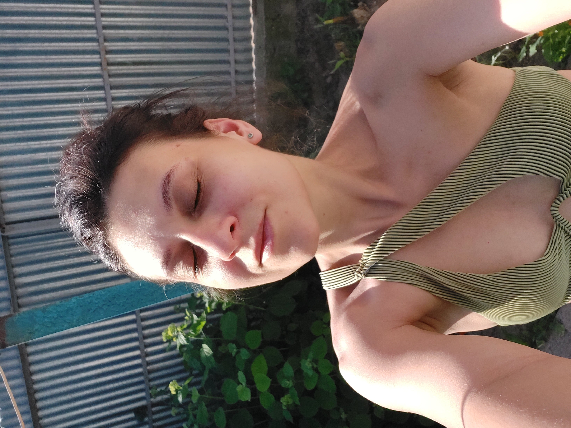 Woman takes outdoor selfie in striped swimsuit in Tavaksay