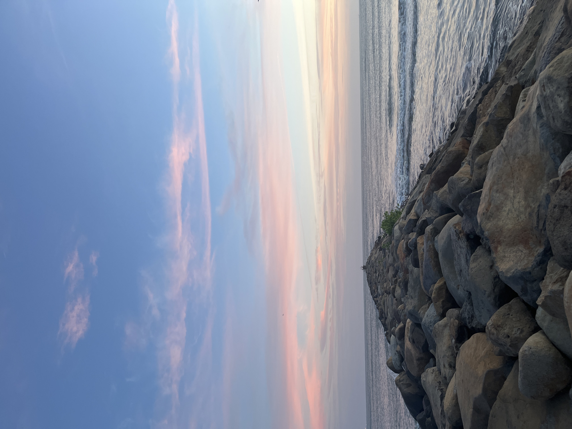 Sunset over a quiet Indonesian coastal jetty and shoreline