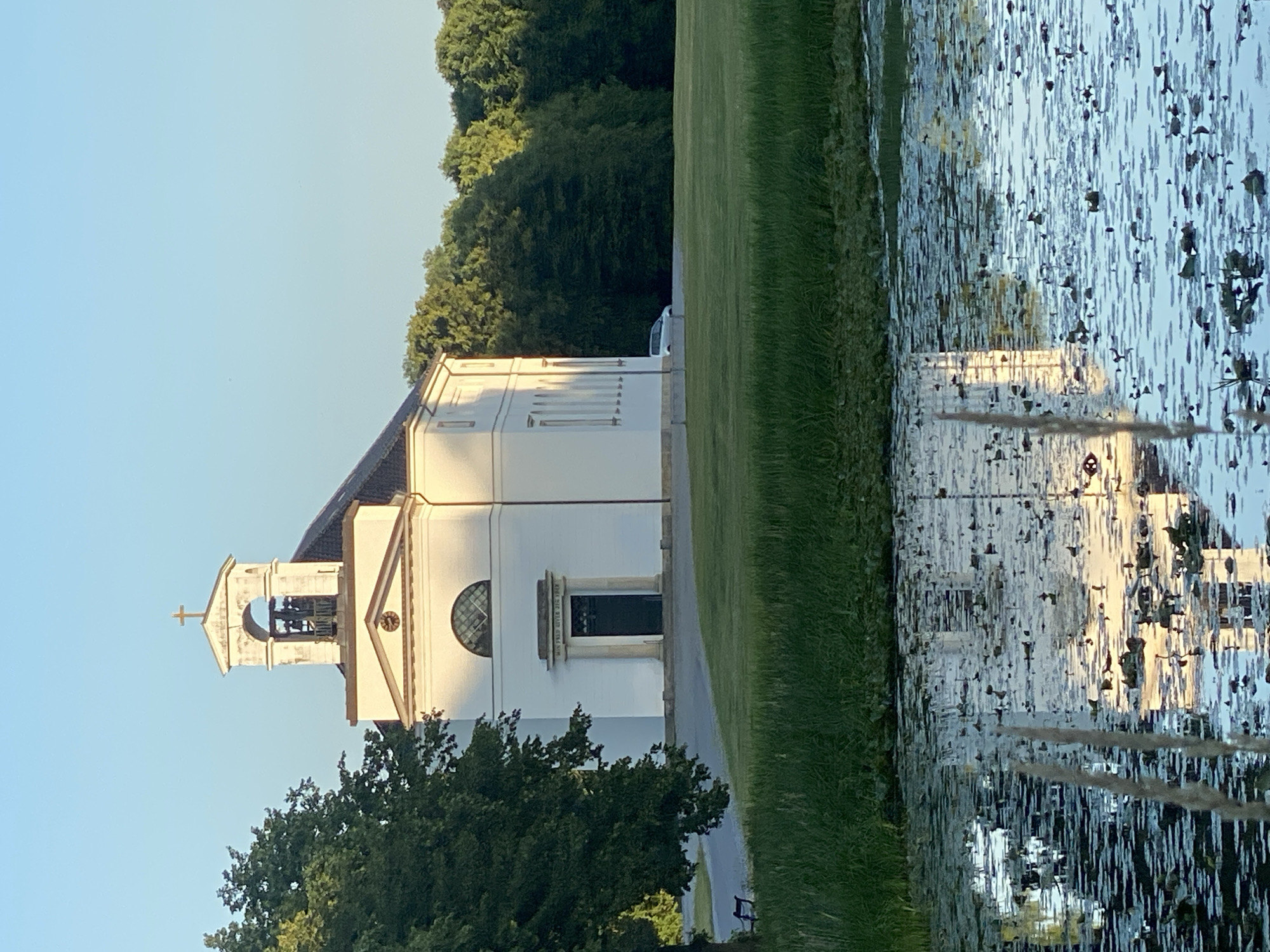 Hørsholm Church at golden hour, with a cyclist passing by