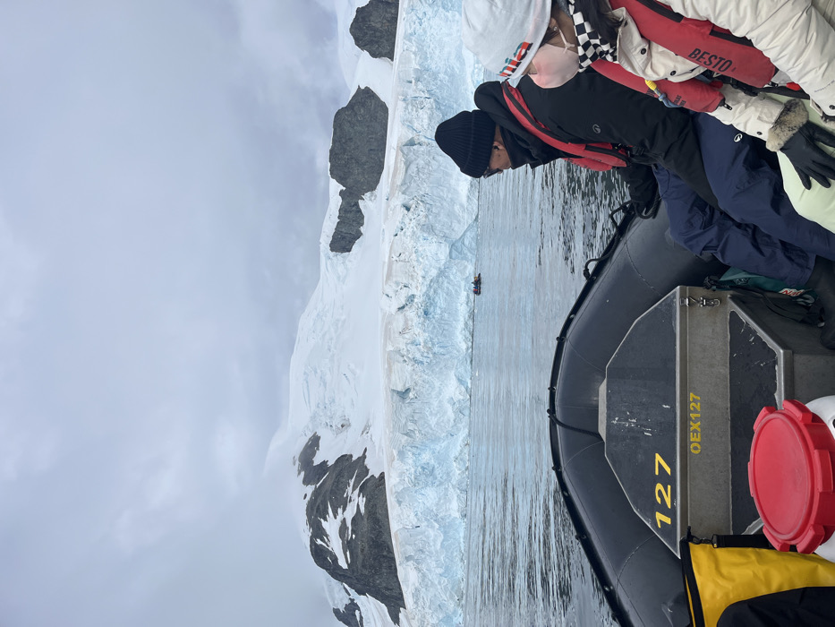 Tourist group observes glacier from inflatable boat amid cloudy weather