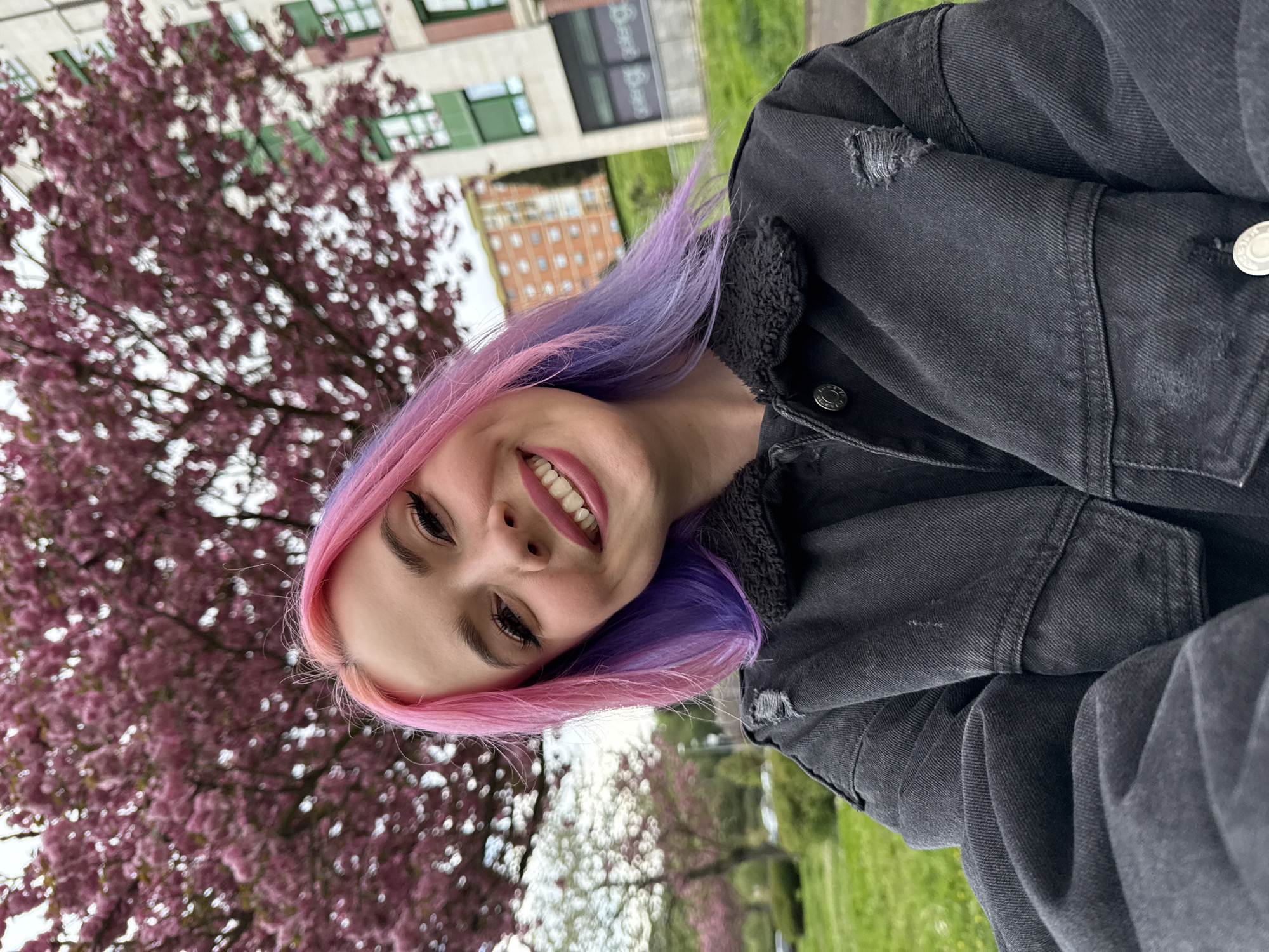 Woman takes selfie by cherry blossoms in Oviedo