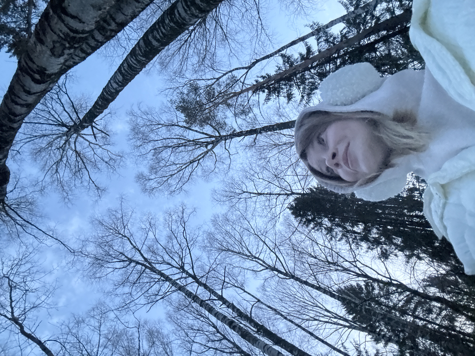 Woman explores snowy forest near Vassyata, Russia winter afternoon