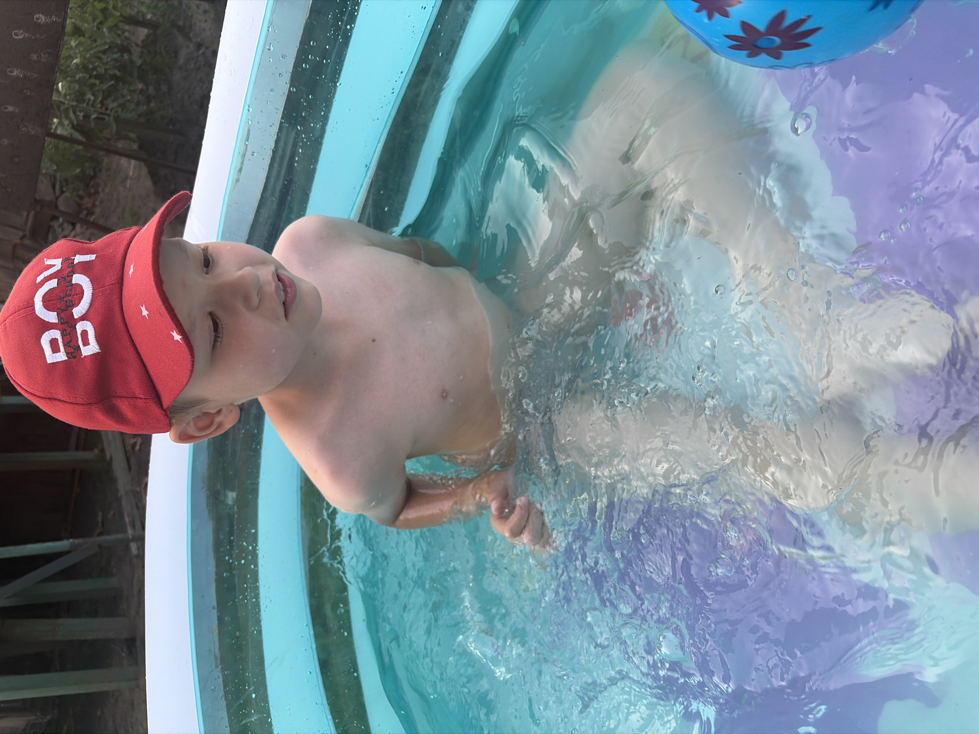 Kids cooling off in a backyard inflatable pool on a sunny afternoon