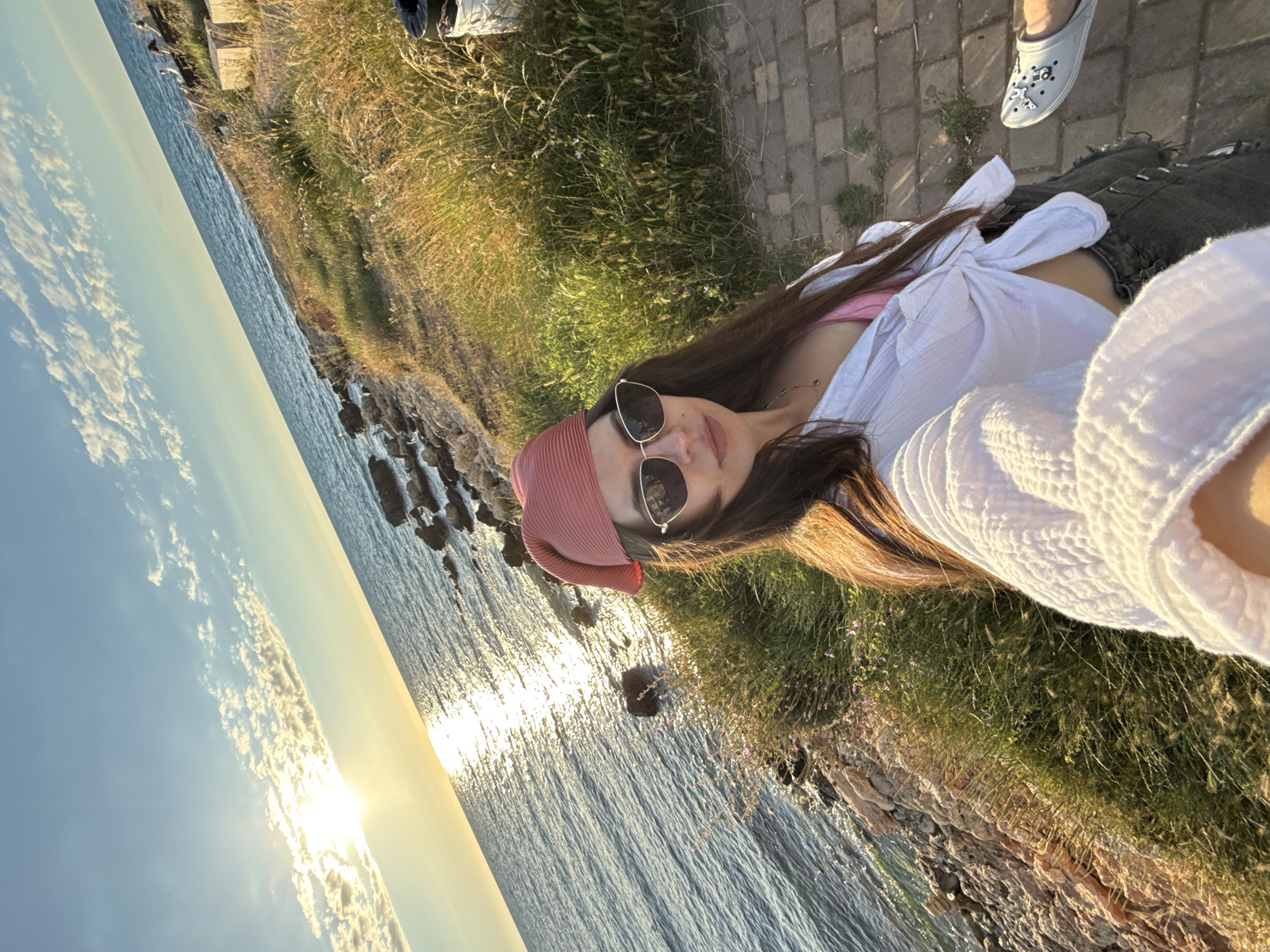 Golden hour on the rocks, drinks in hand, ocean at sunset
