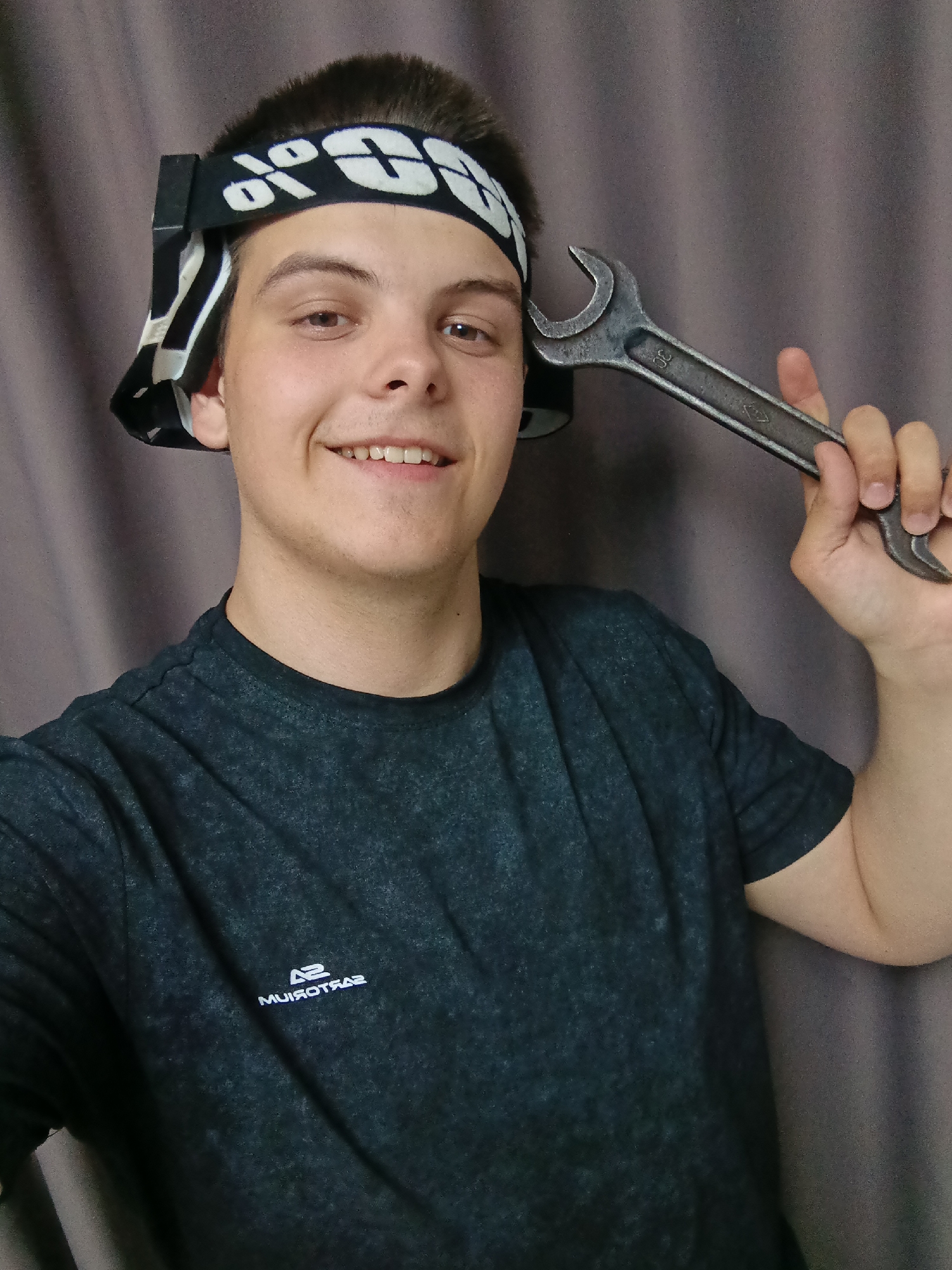 Young man poses with assorted objects in indoor photo session