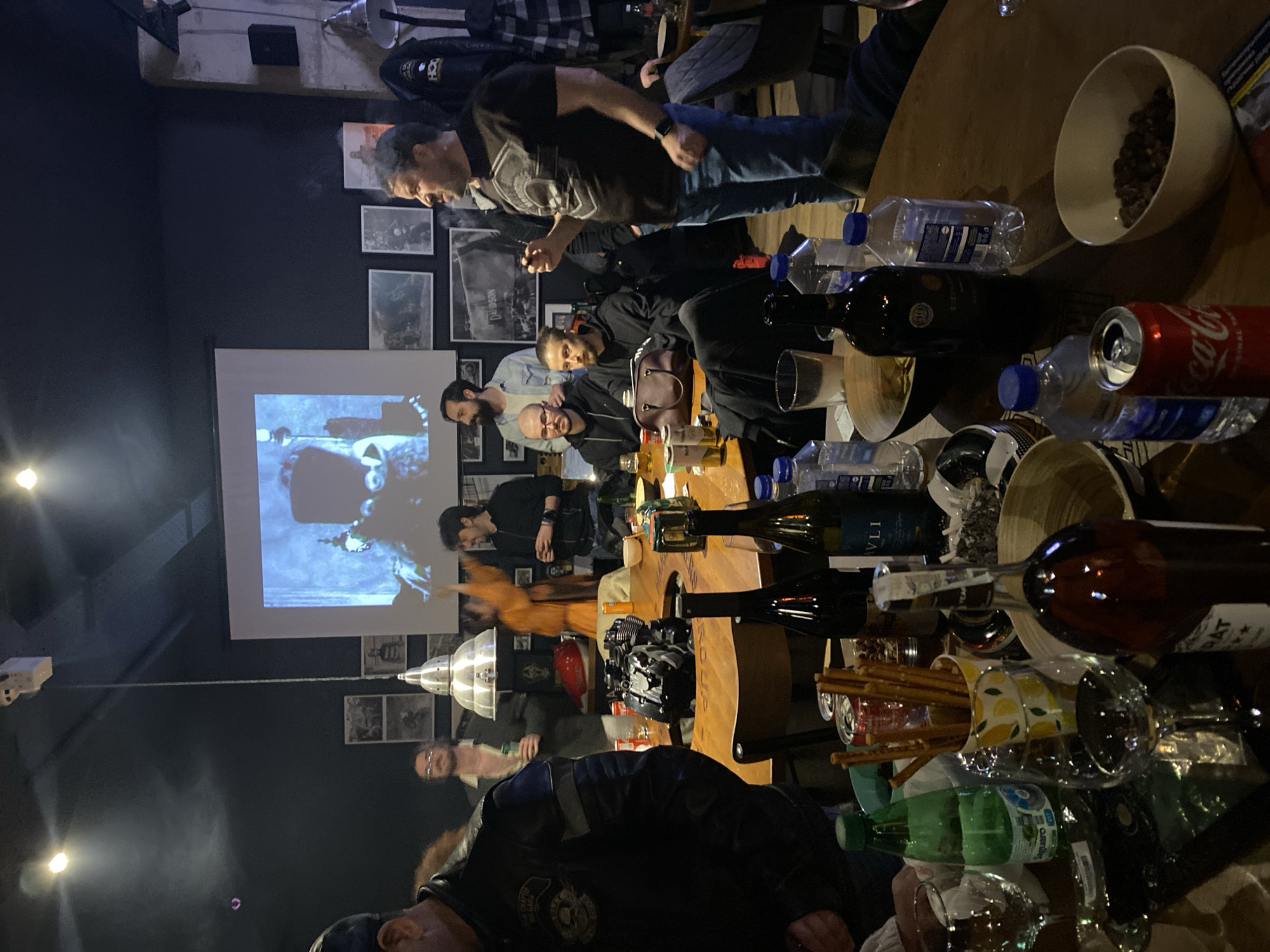 Group gathers around table in dimly lit venue